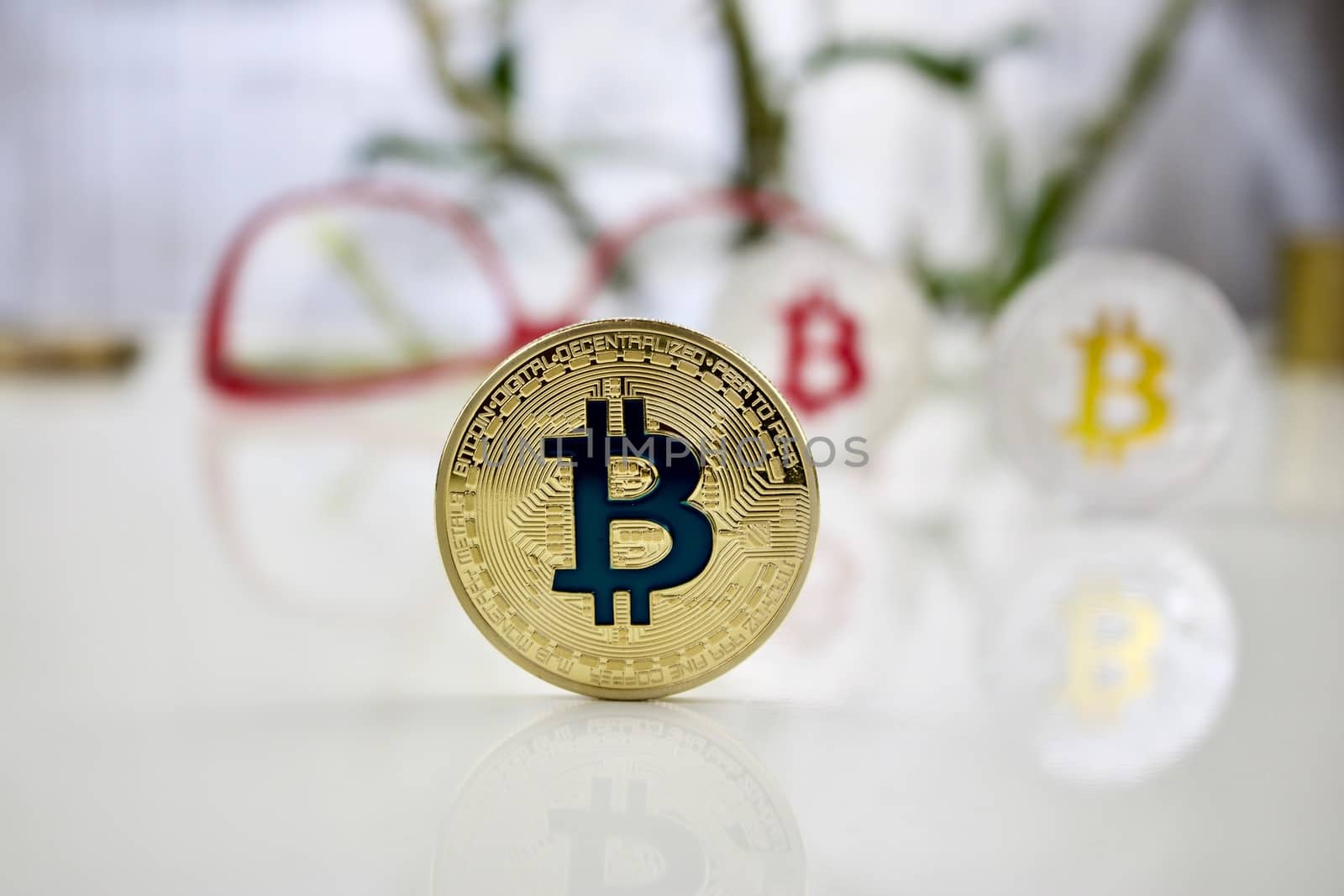 Digital currency physical colored bitcoin coins near pink glasses