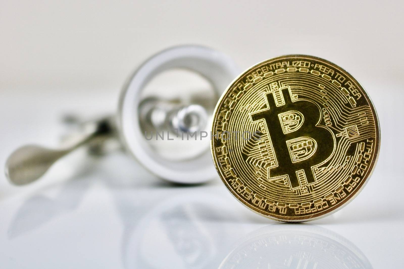 Gold bitcoin physical cryptocurrency coin and silver wine opener.