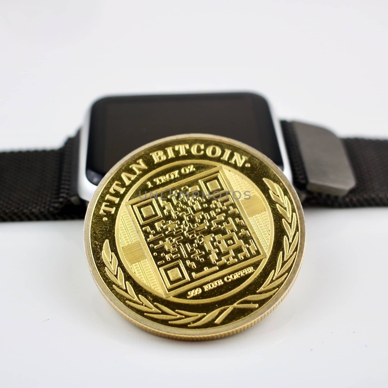Cryptocurrency physical gold titan bitcoin and black smartwatch.