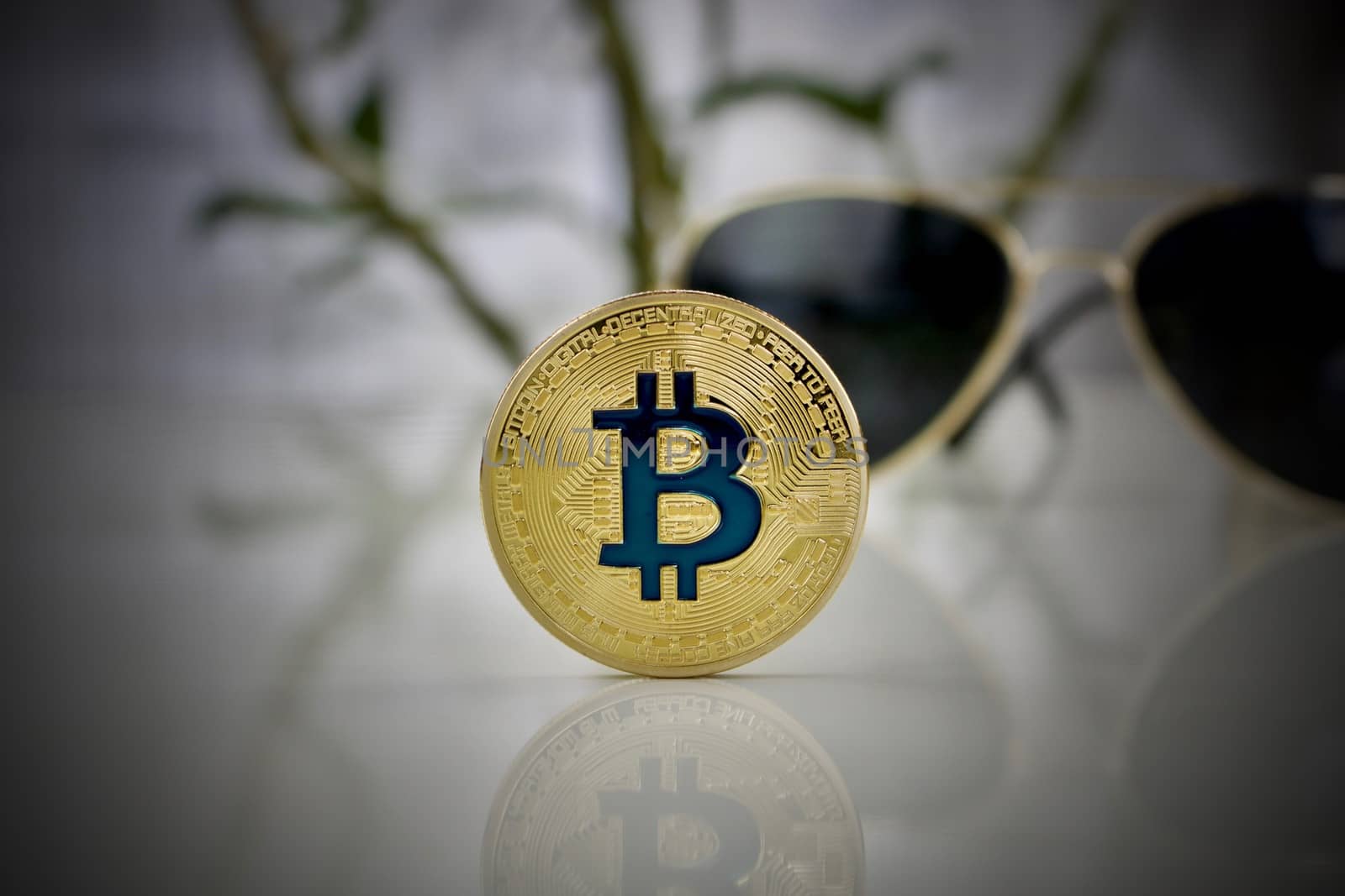 Digital currency physical gold bitcoin coin and gold sunglasses