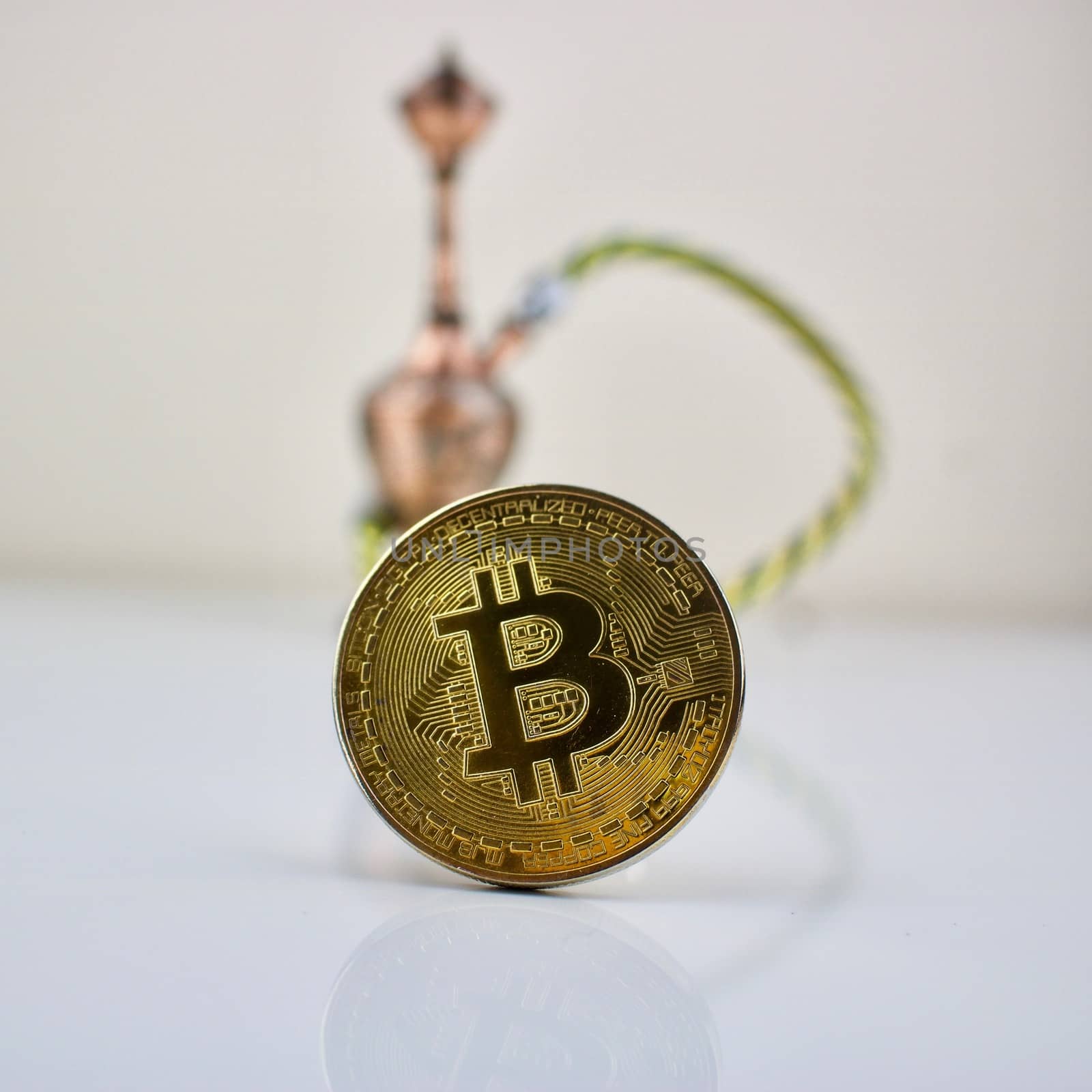 Cryptocurrency physical gold bitcoin coin and small sisha.