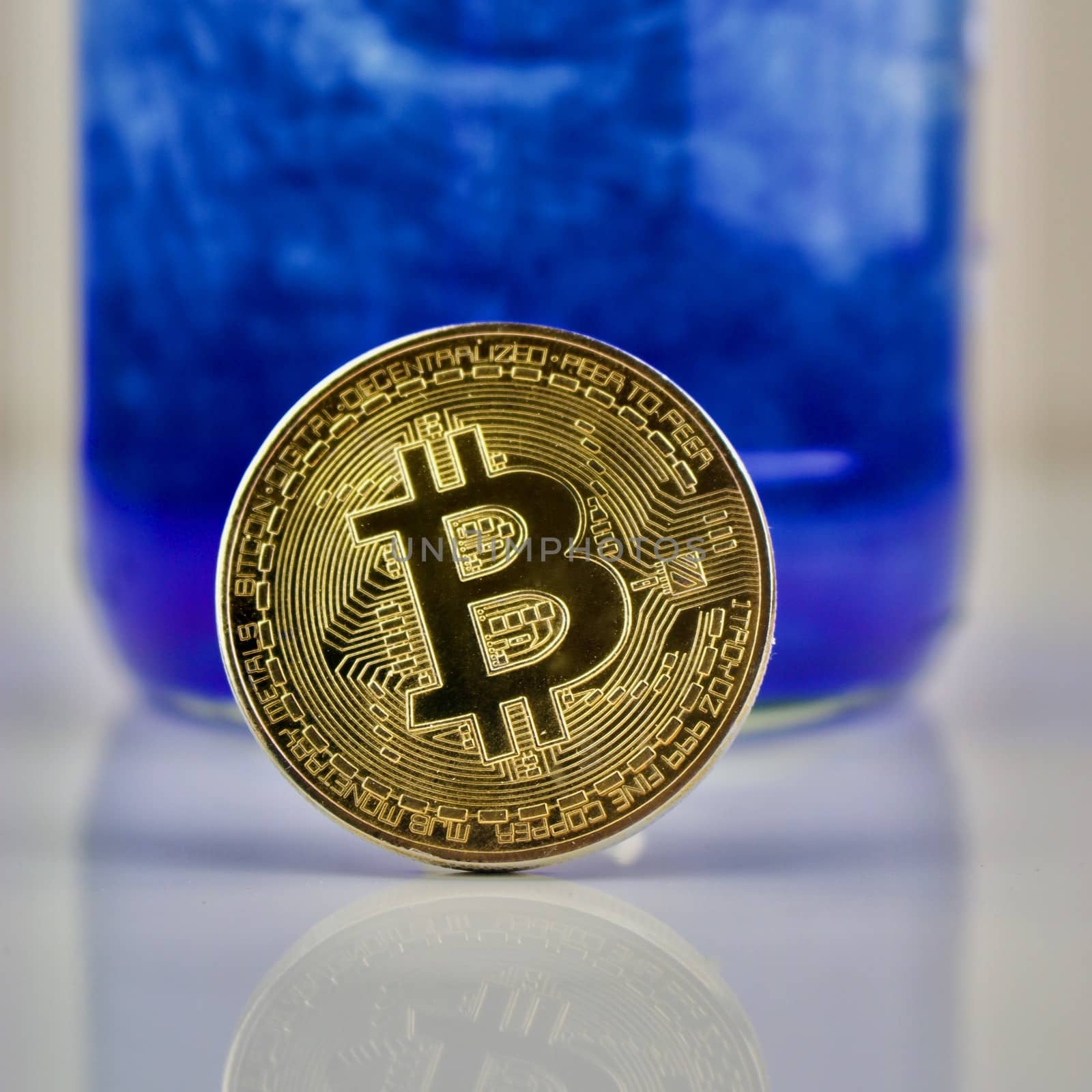 Cryptocurrency physical gold bitcoin coin on blue pattern