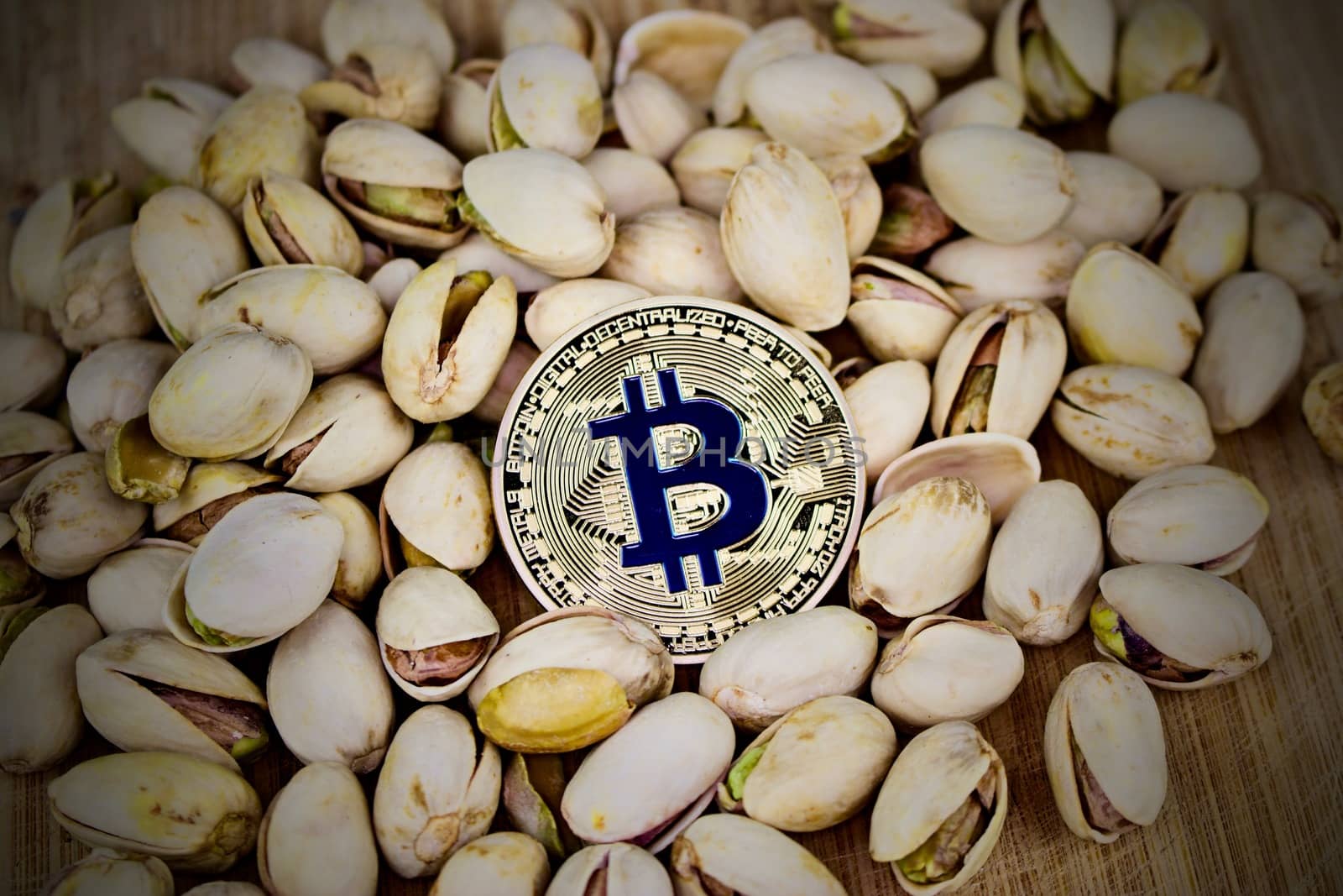 Cryptocurrency physical gold bitcoin coin in pistachios nuts.