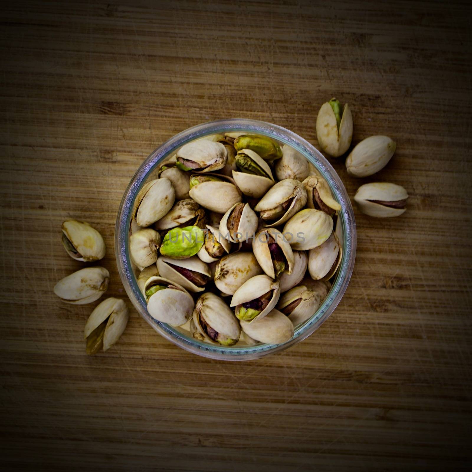 Pistachios nuts glass concept on old wooden board
