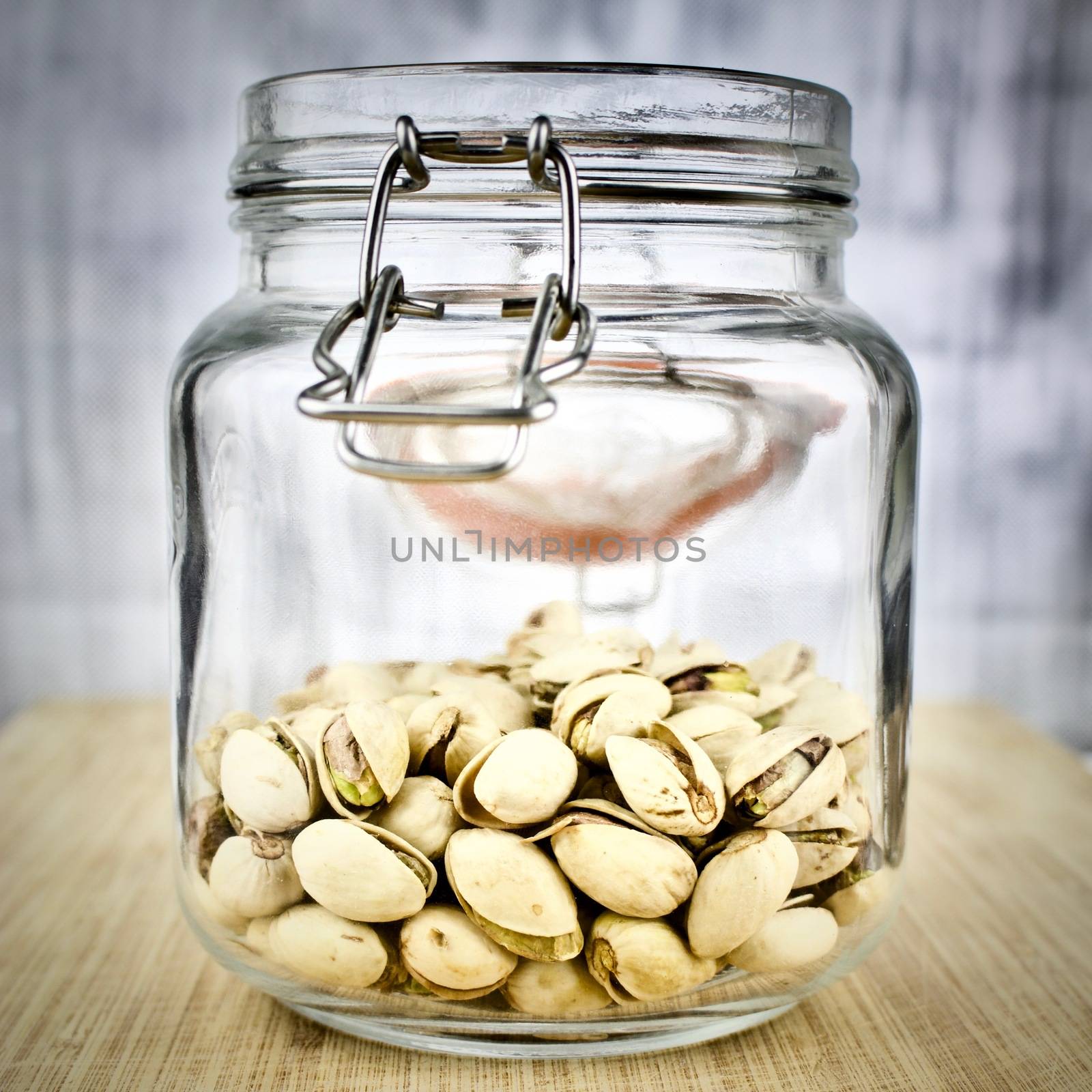 Pistachios in glass jar on the wooden board