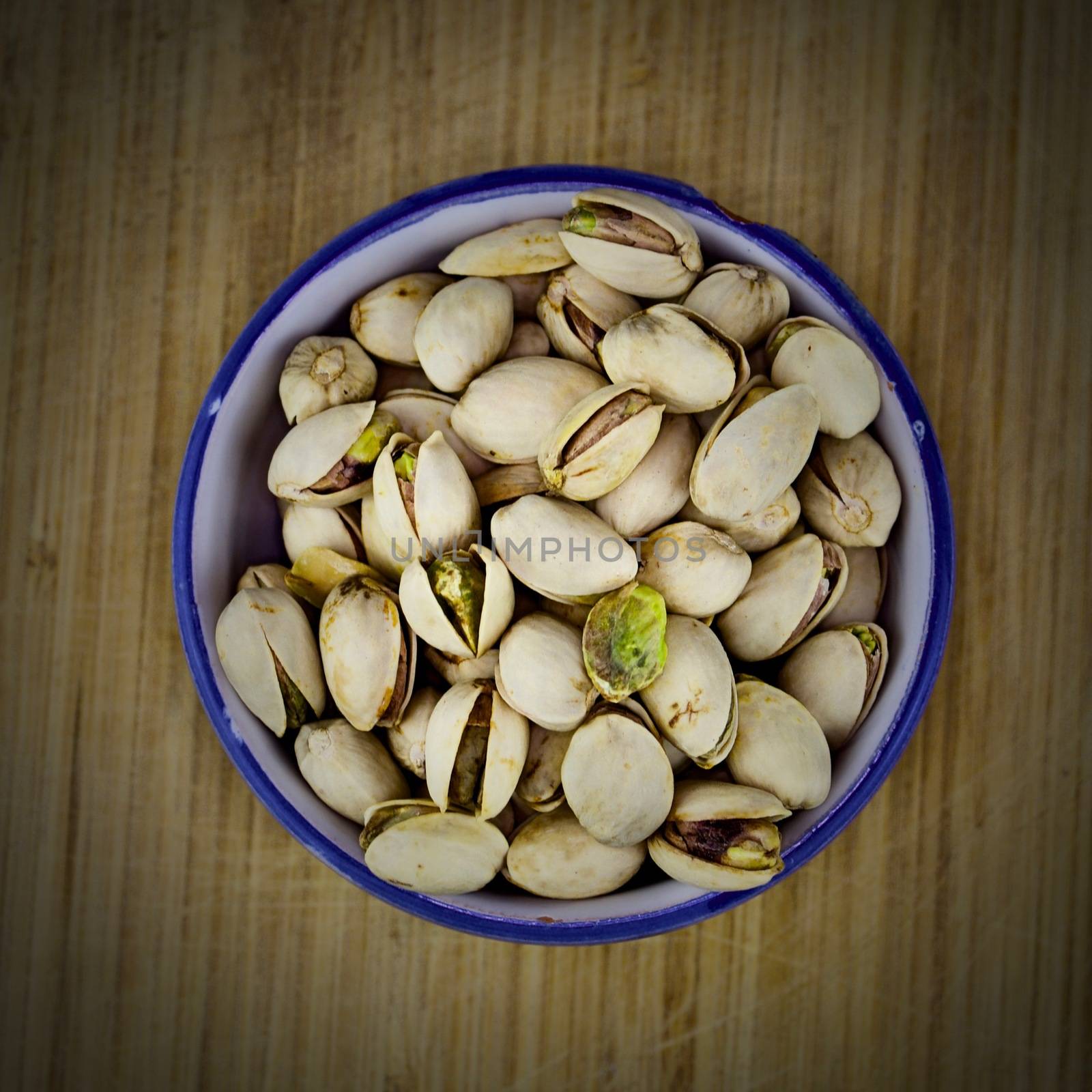 Tasty pistachios on the wooden board.