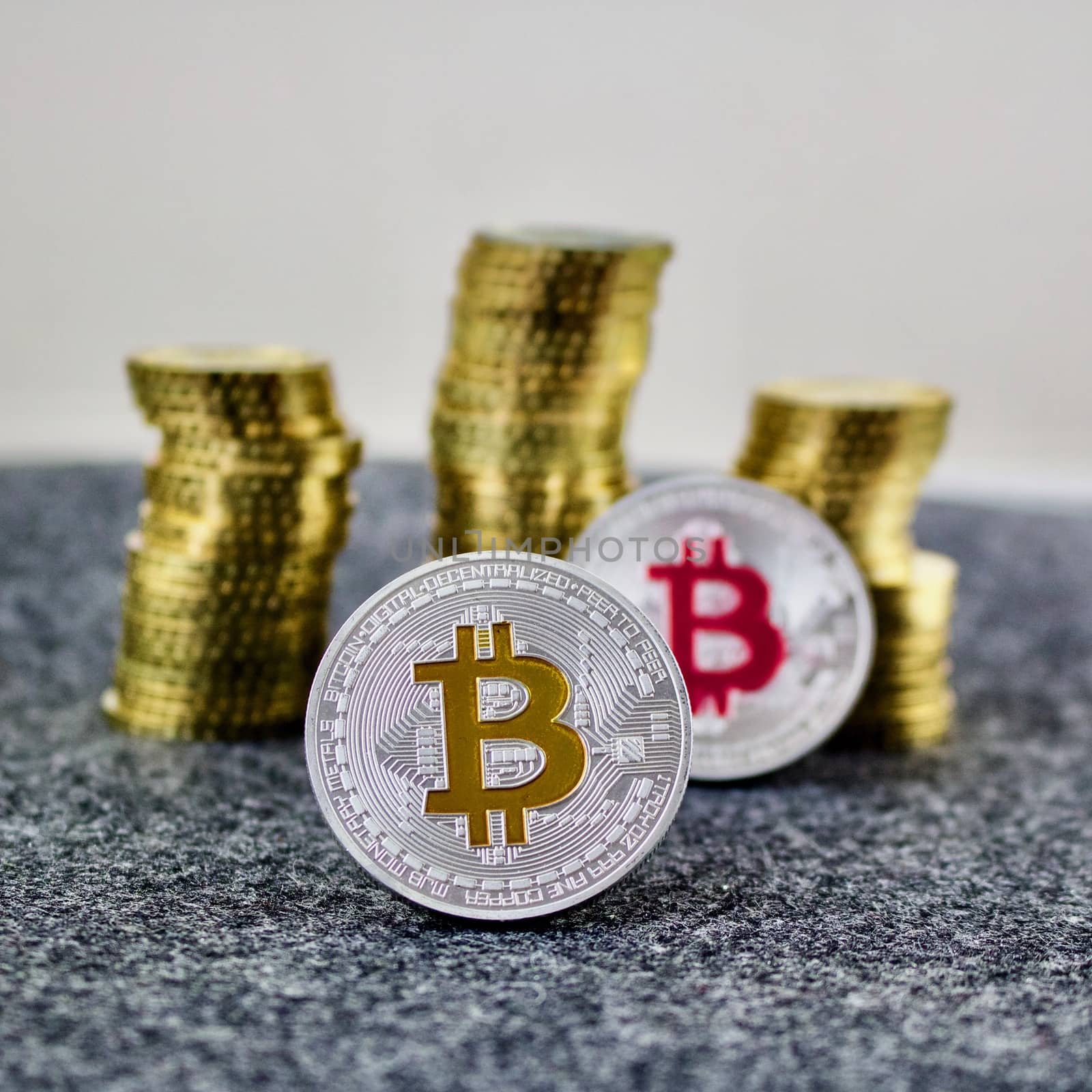 Cryptocurrency physical silver bitcoin coin with yellow and pink sign.