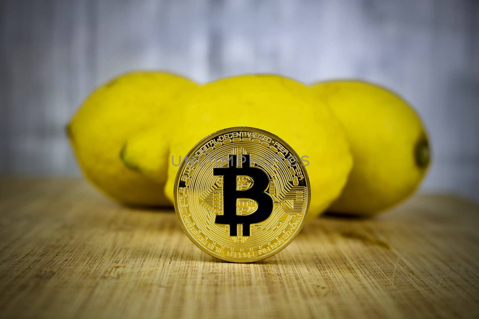 Cryptocurrency physical gold bitcoin coin near yellow lemons