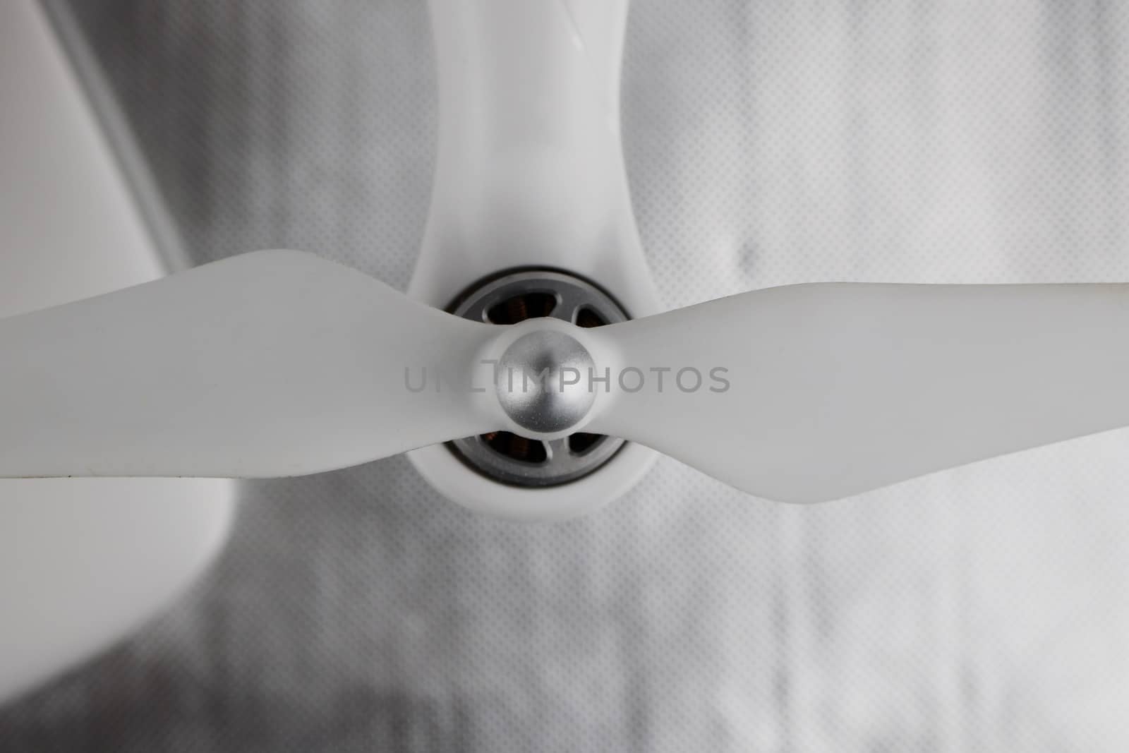 White long airscrew on the white quadcopter with silver engine.
