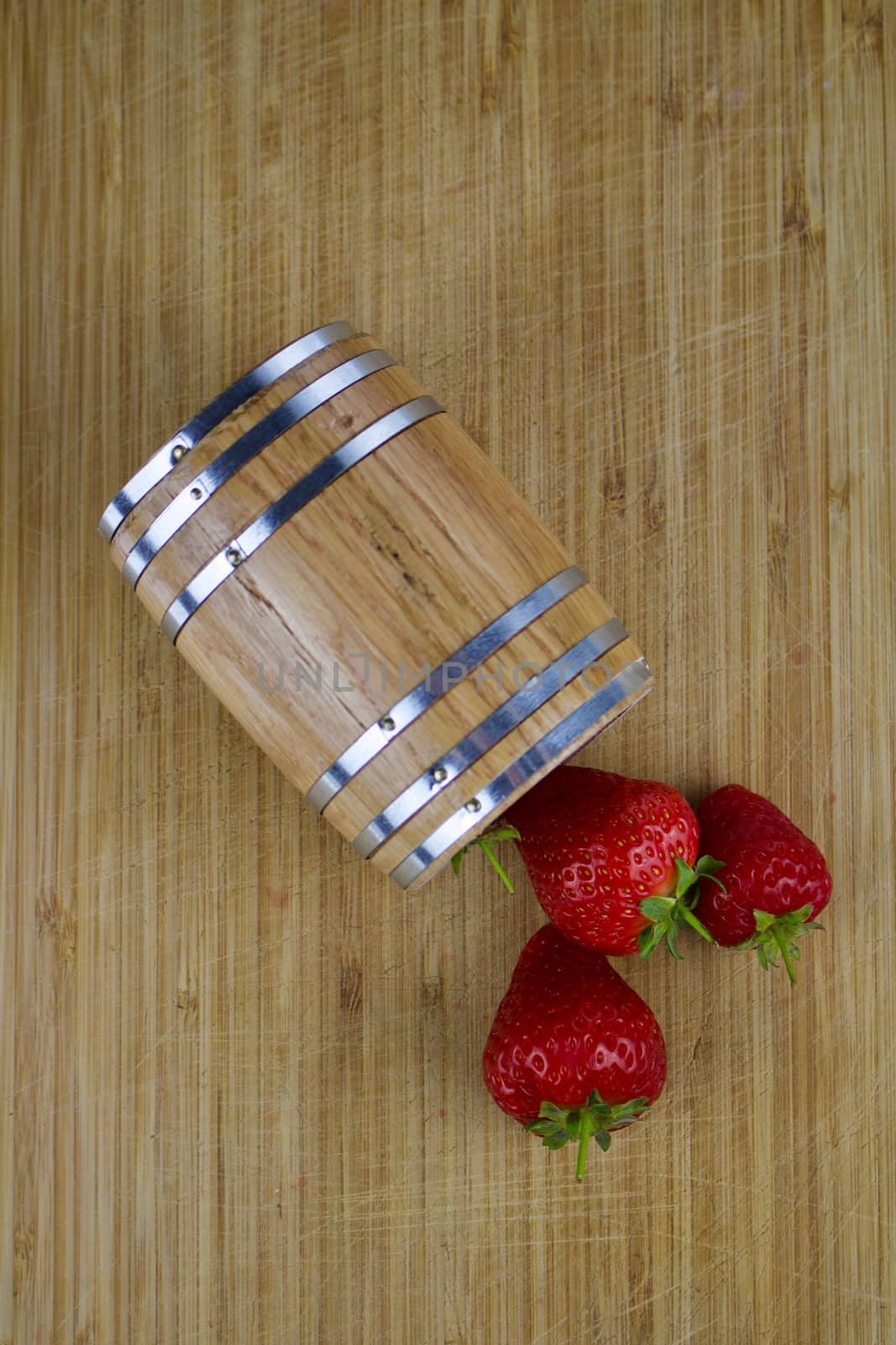 Fresh red strawberries and wooden barrel on the wooden board