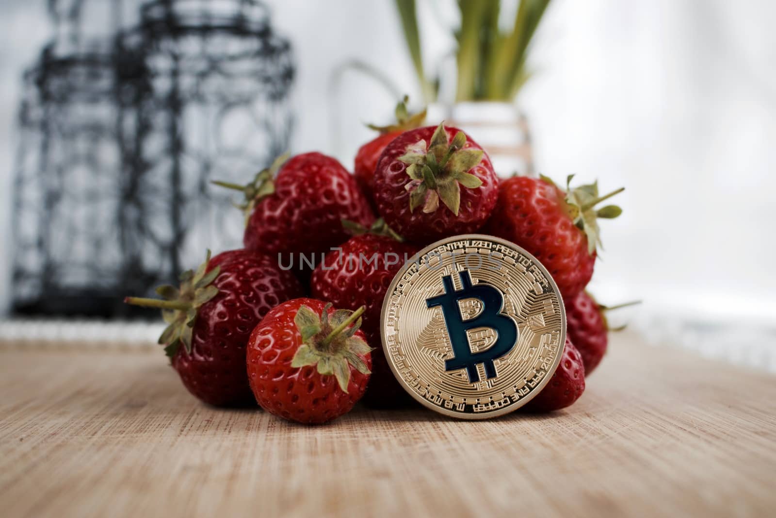Cryptocurrency physical gold bitcoin coin and strawberries. Fruit concept.