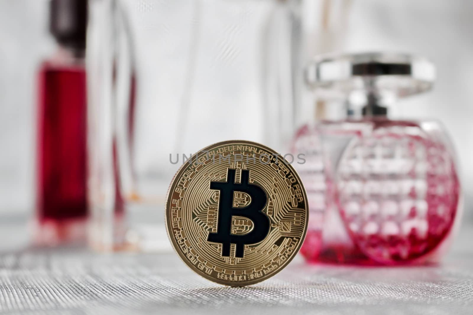 Digital currency physical gold bitcoin coin - pink perfume composition.