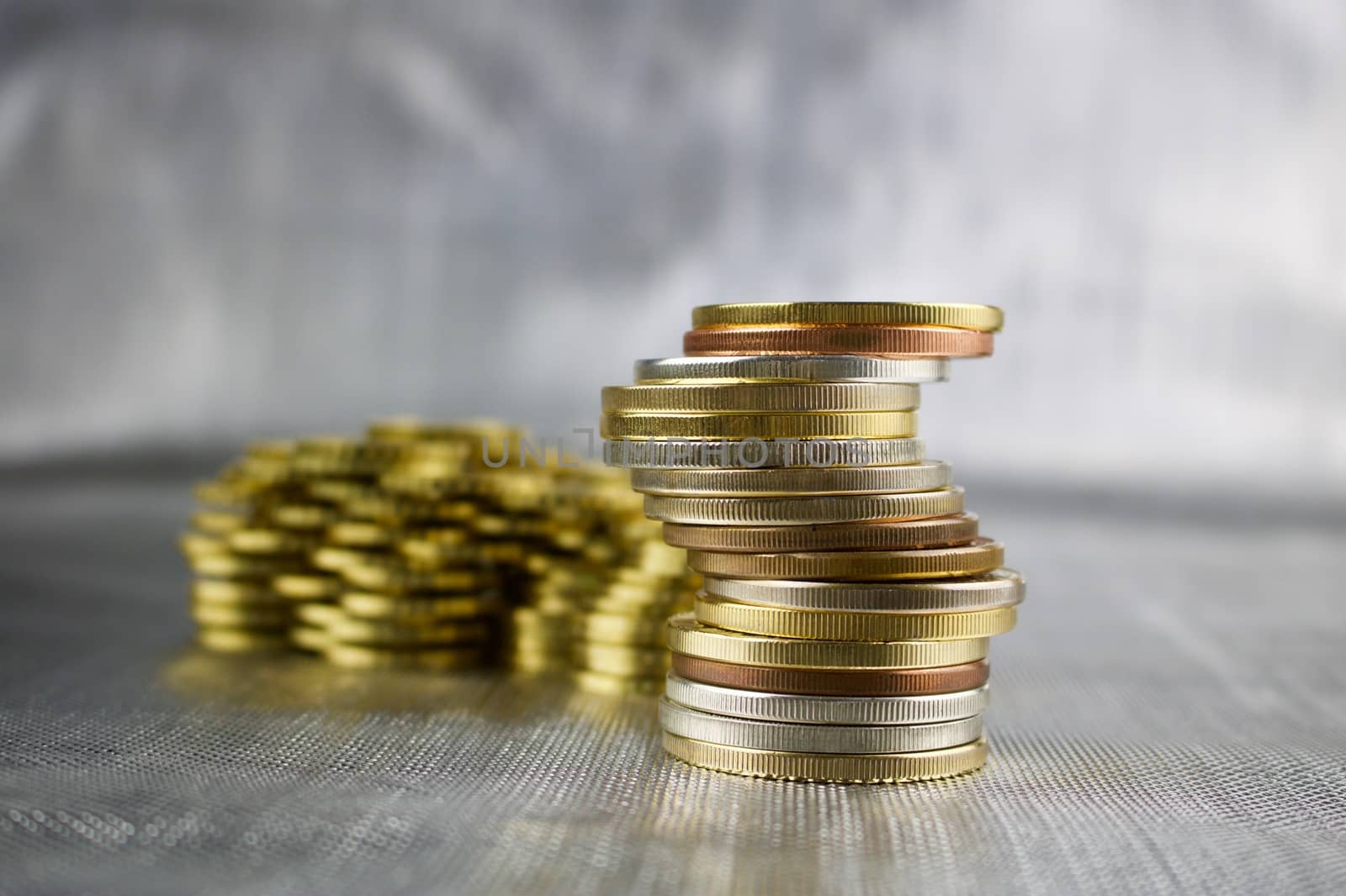 Money concept. Big tower coins on the silver background.