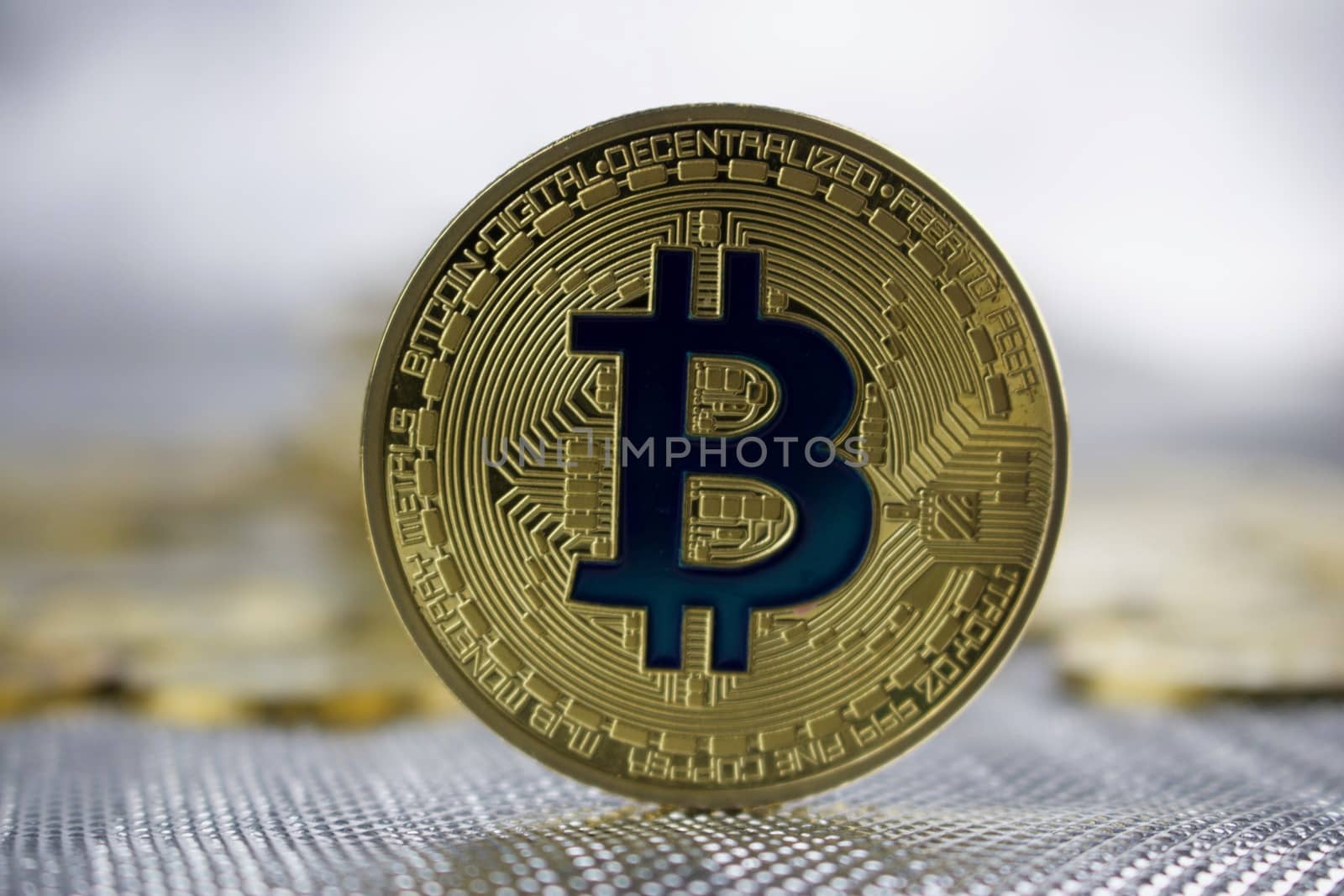 Cryptocurrency physical gold bitcoin coin with a blue sign.