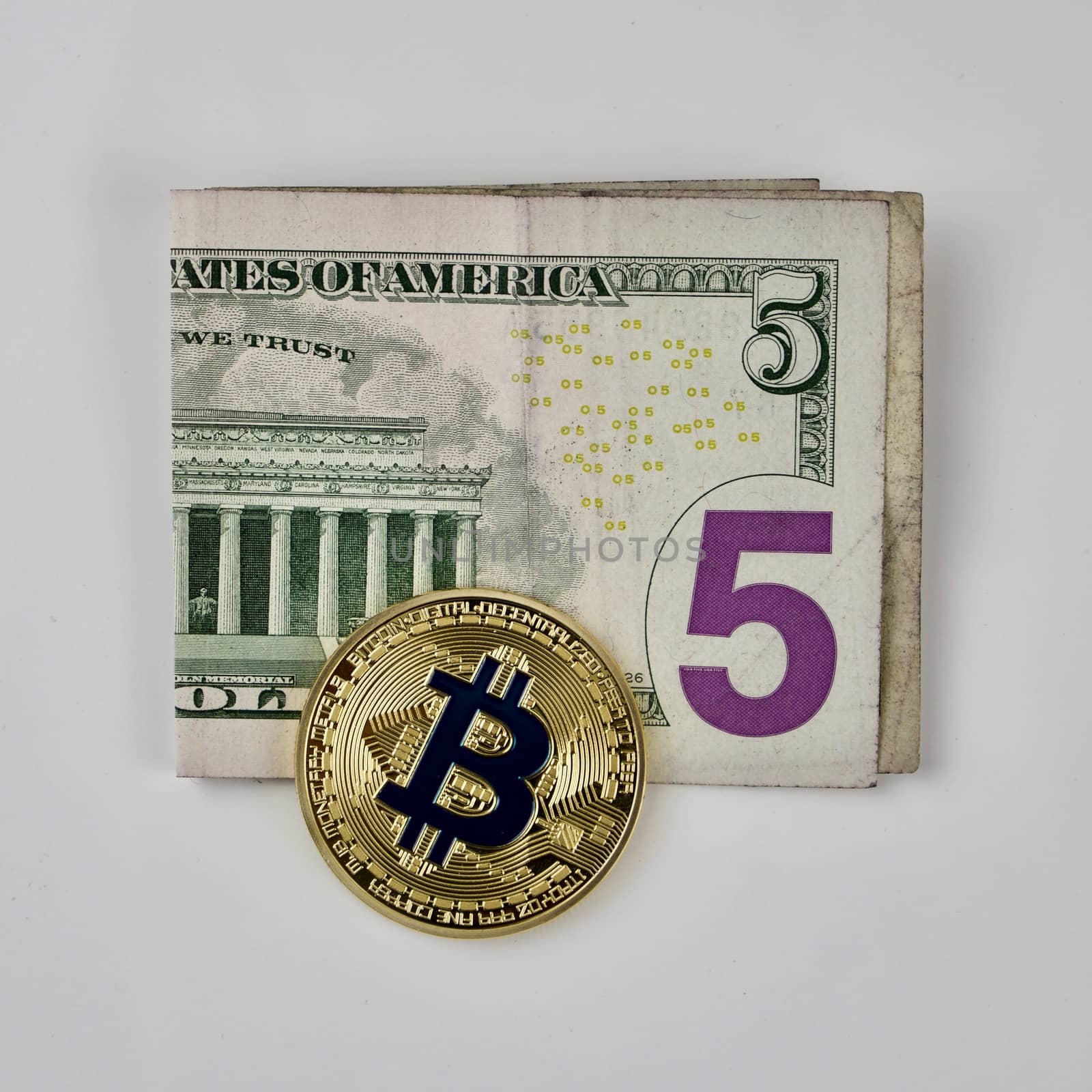 Cryptocurrency physical gold bitcoin coin on the five dollars.