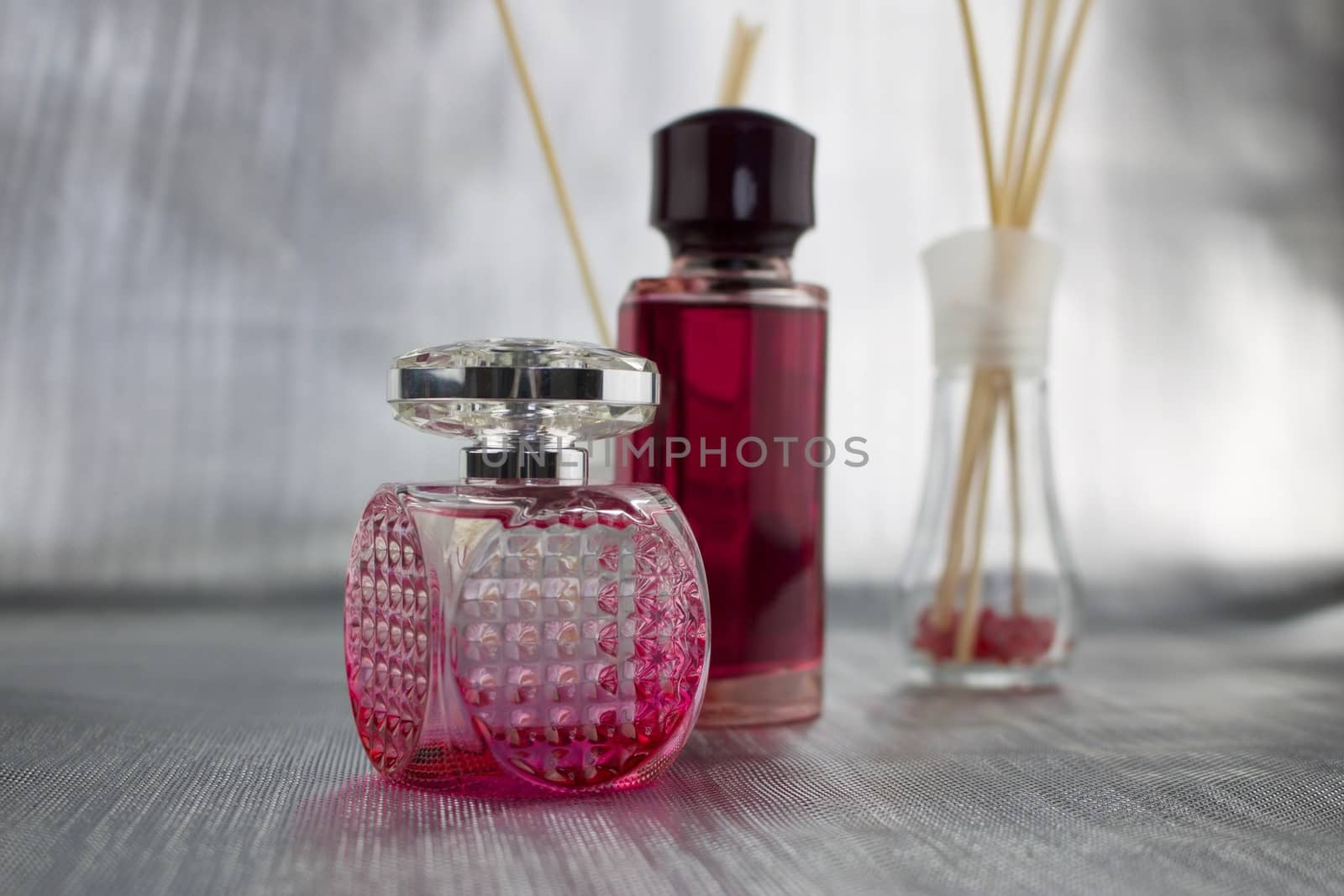 Two bottles with a pink fragrances on the table.