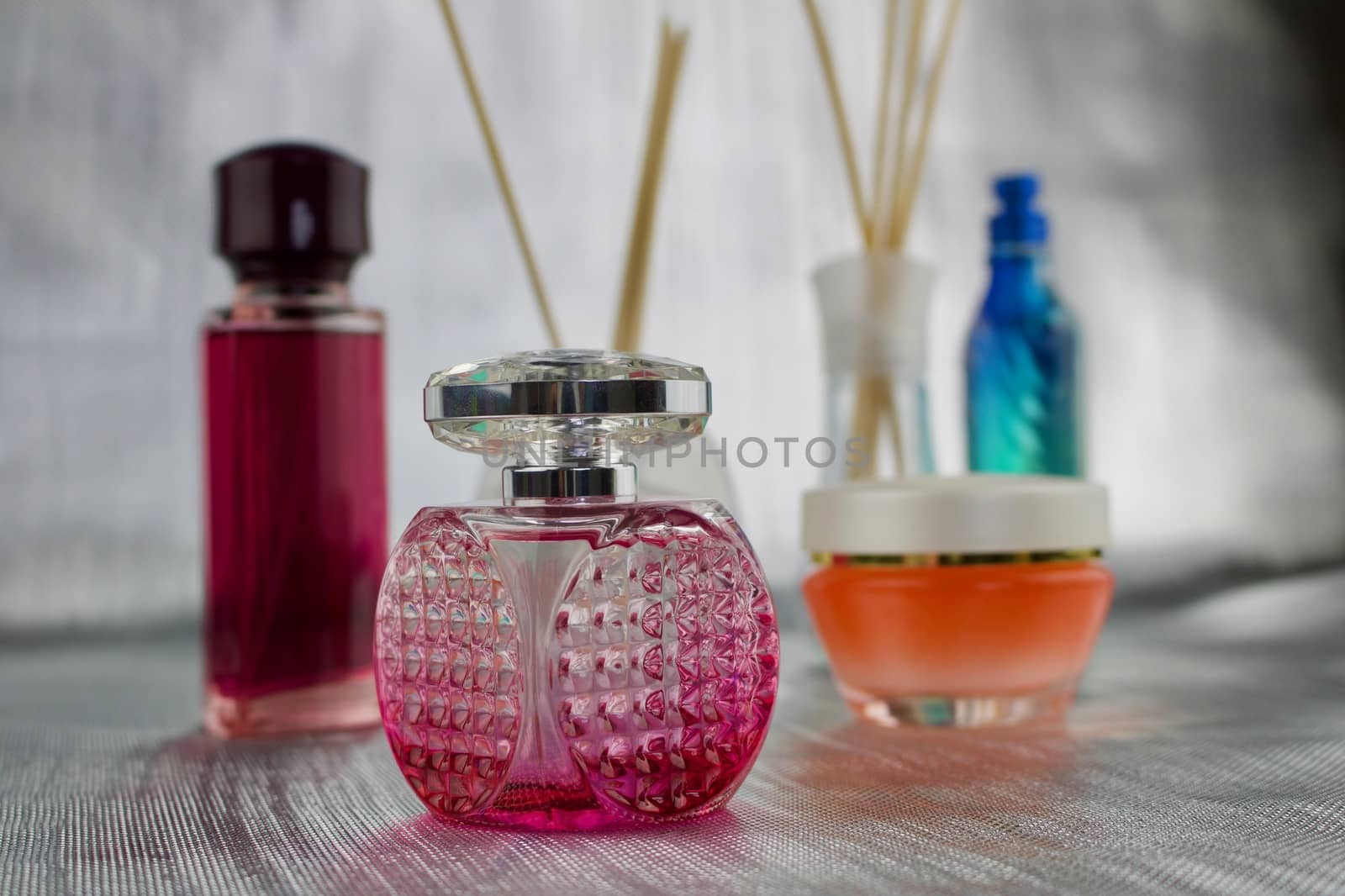 Fragrance in pink bottles on the table near orange creme.