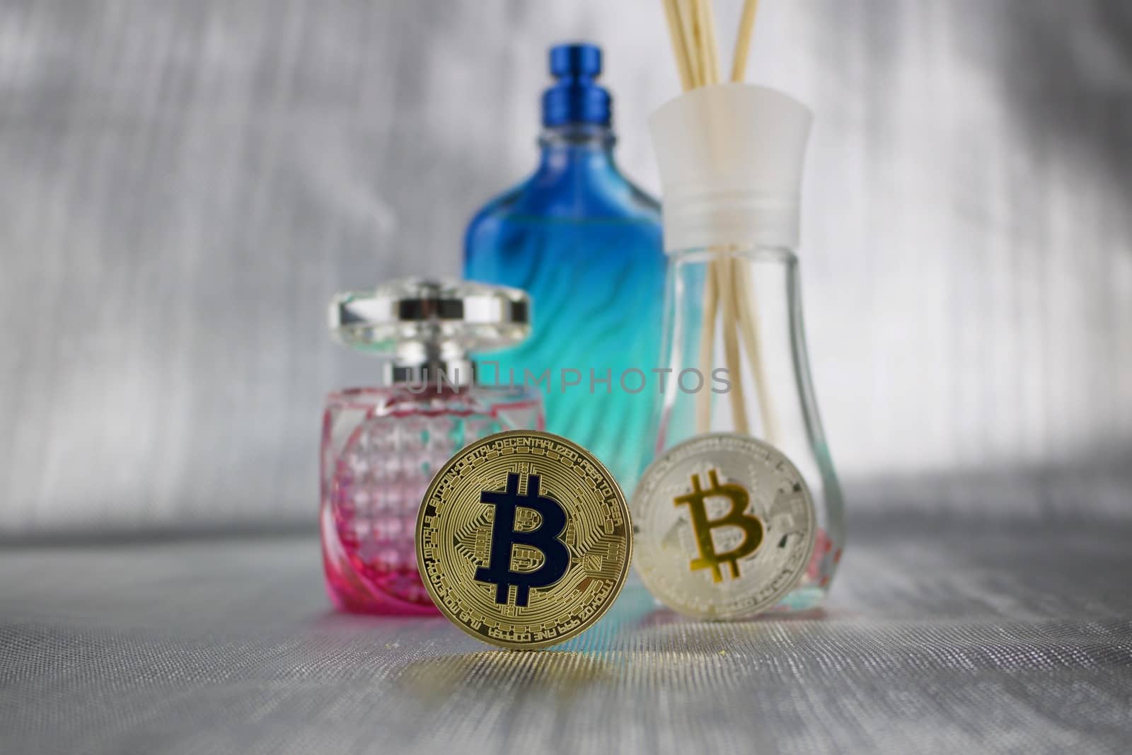 Cryptocurrency physical gold and silver bitcoins near fragrances