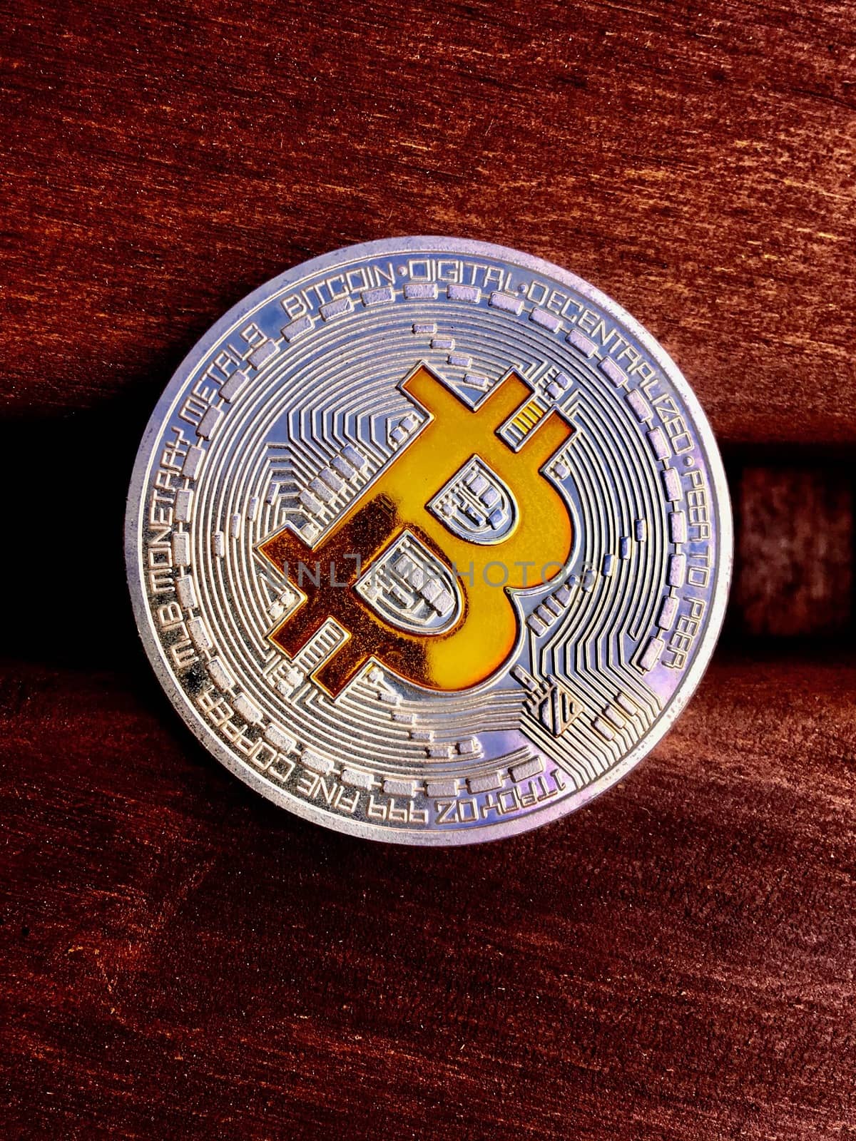 Cryptocurrency silver bitcoin coin on the red wood