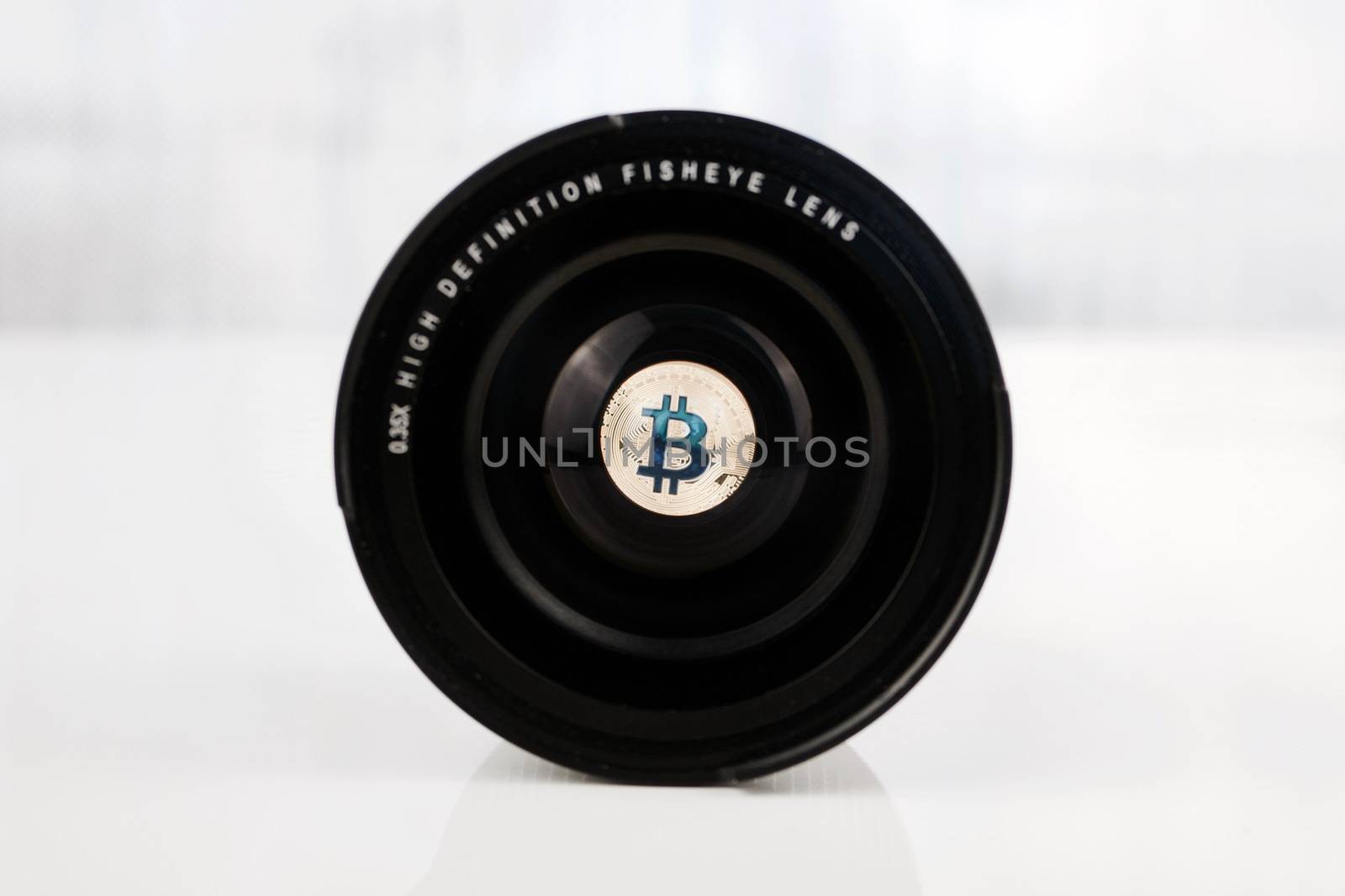 Cryptocurrency physical bitcoin coin in fisheye lenses