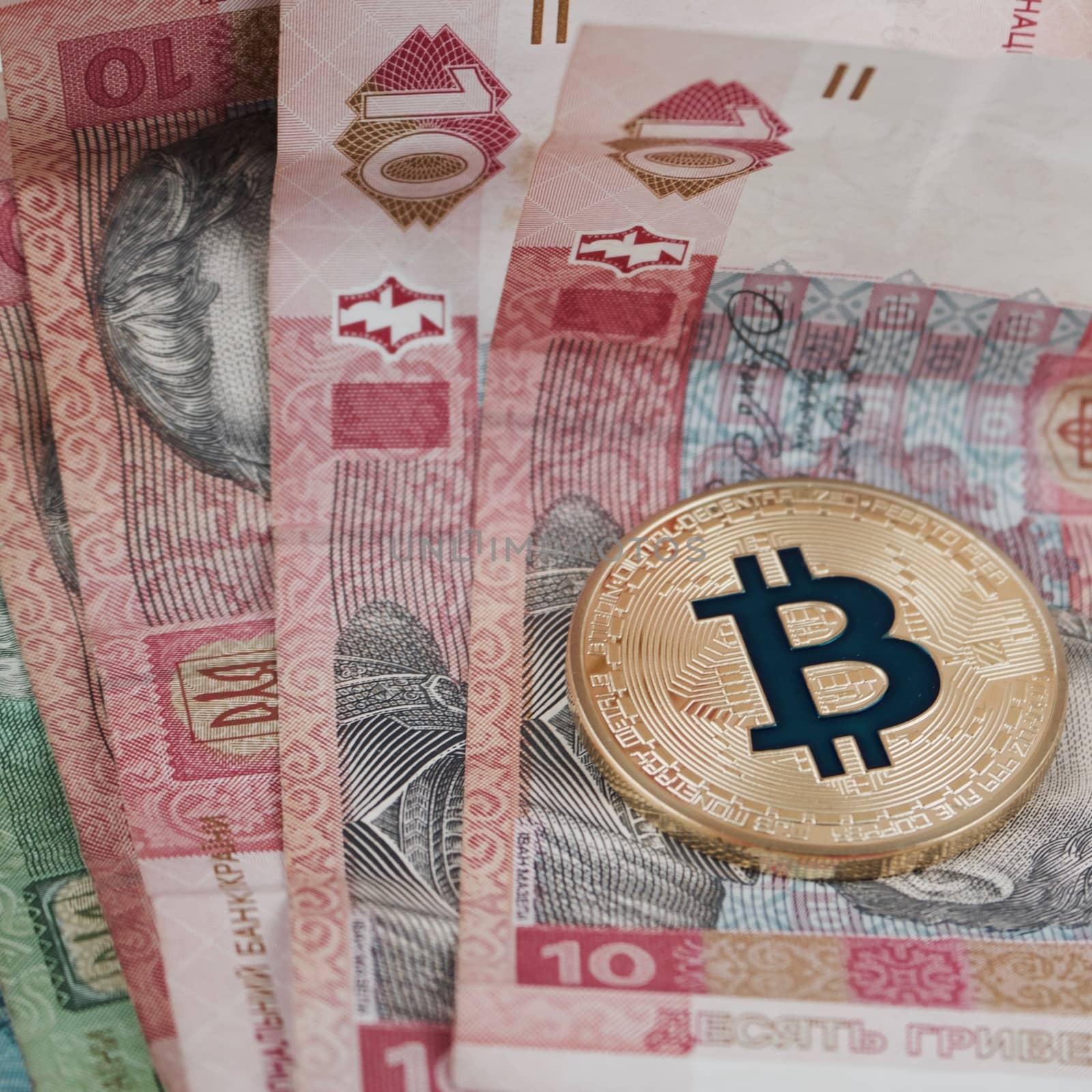 Cryptocurrency physical gold bitcoin coin on the Ukraine money.