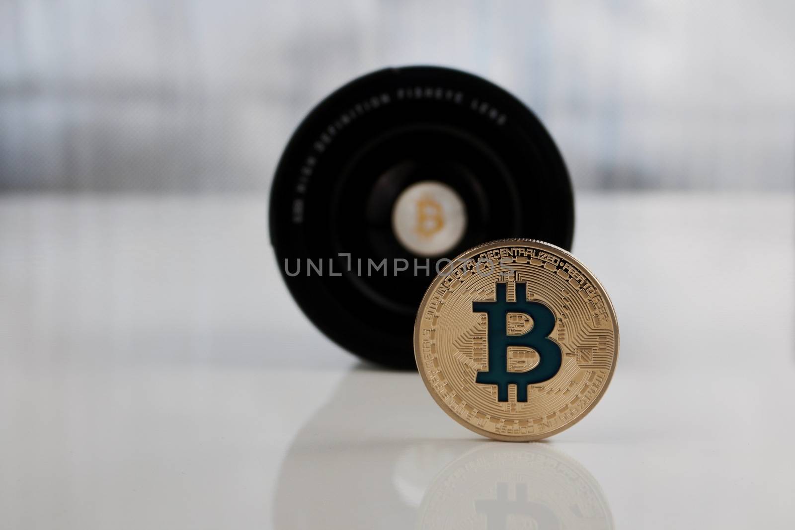 Digital currency physical gold bitcoin coin near lenses.
