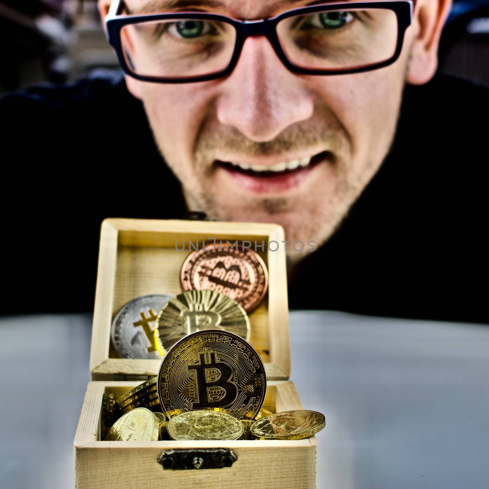 Cryptocurrency physical gold bitcoin coin and man in glasses