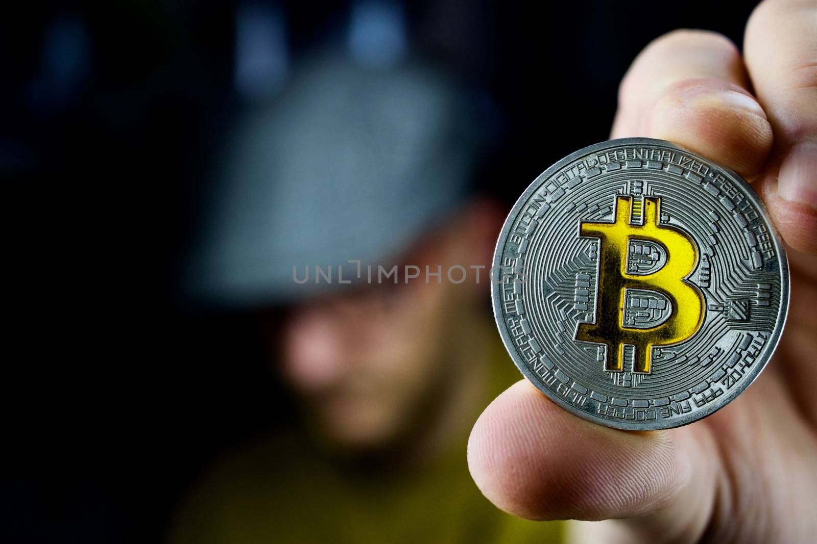 Cryptocurrency physical silver bitcoin coin in man hand
