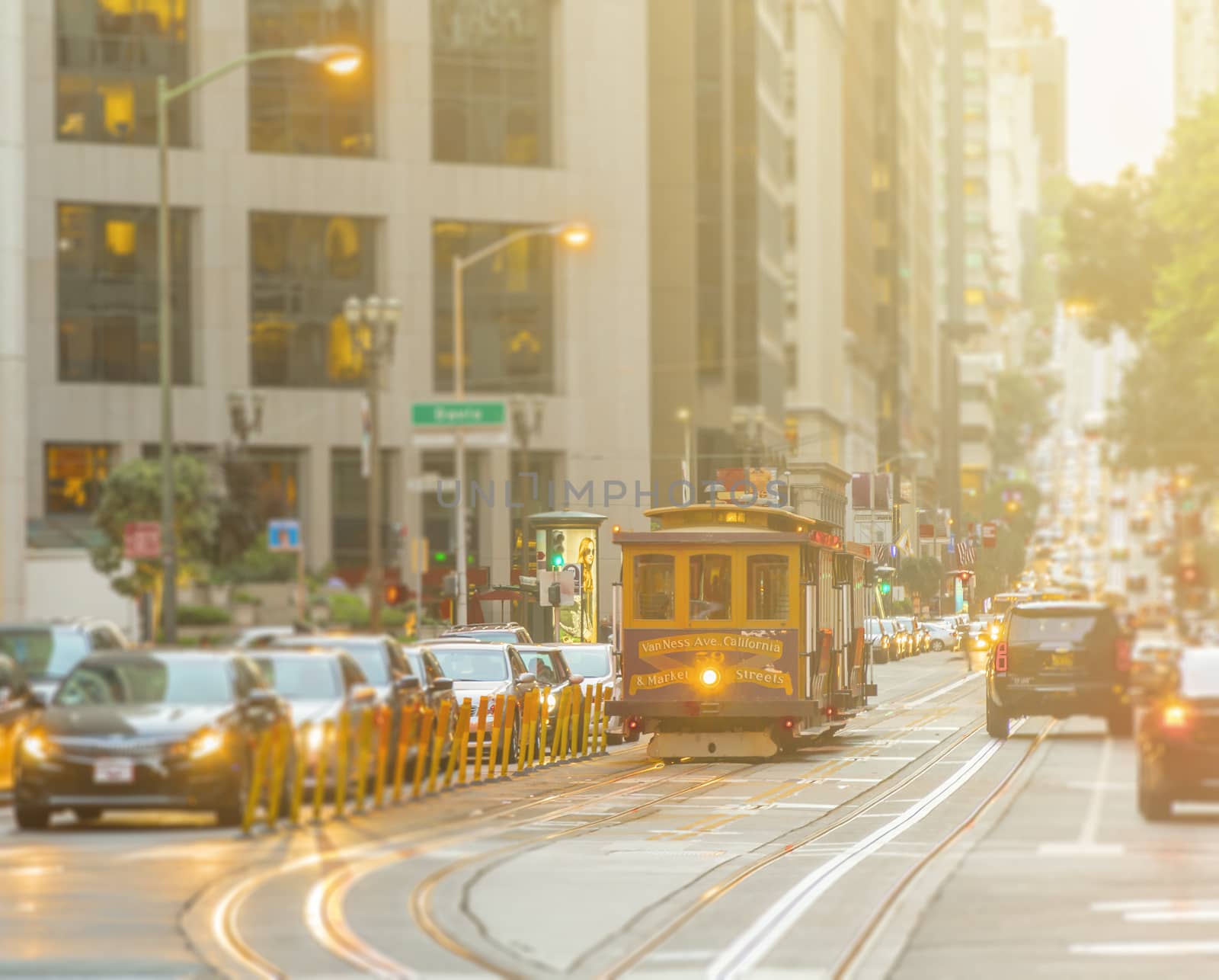 San Francisco Cable Car on focus with blurred traffic on California Street at sunset