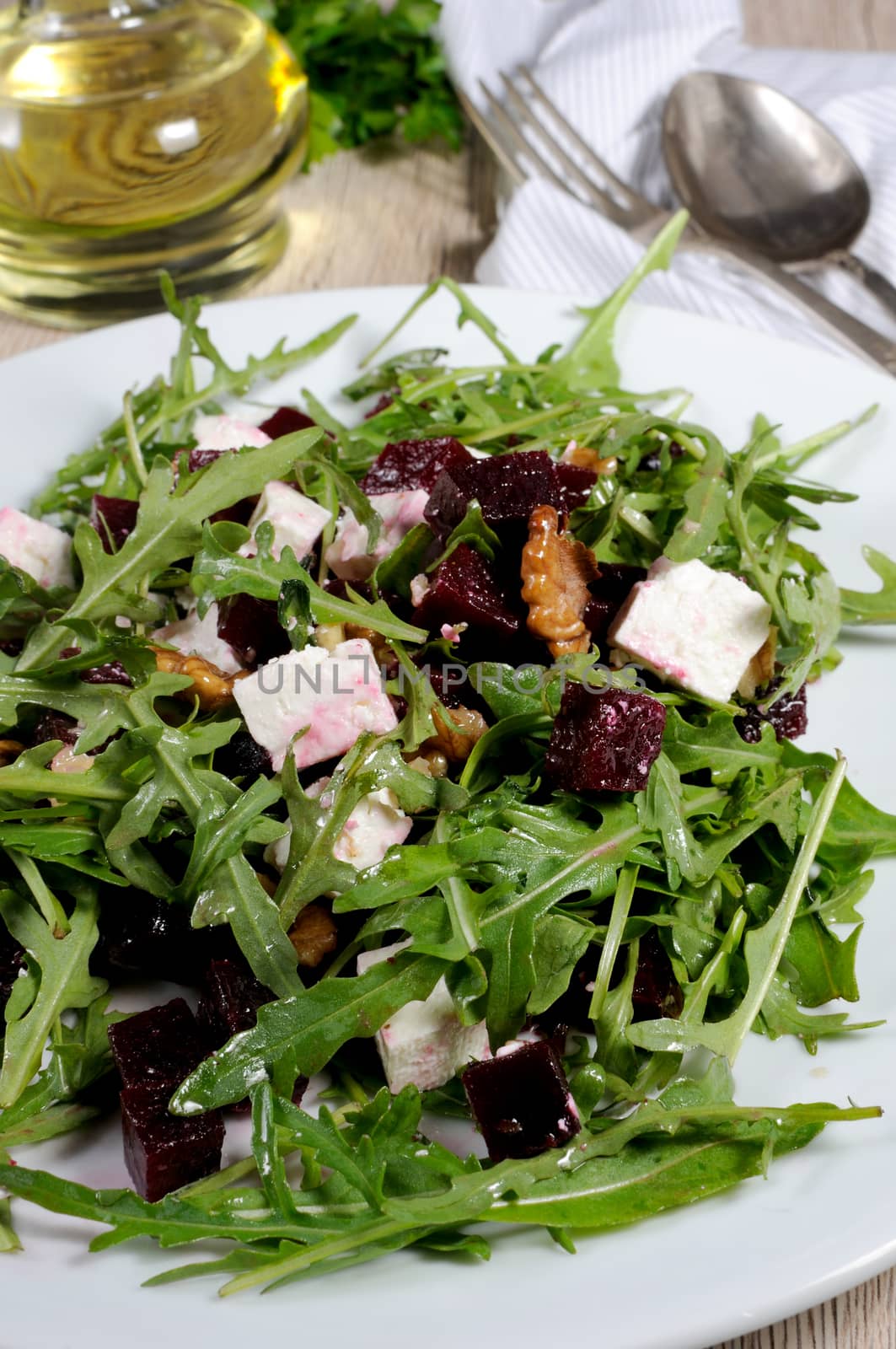 Salad from roasted beets, arugula, cheese feta, and walnuts. Vertical shot. 