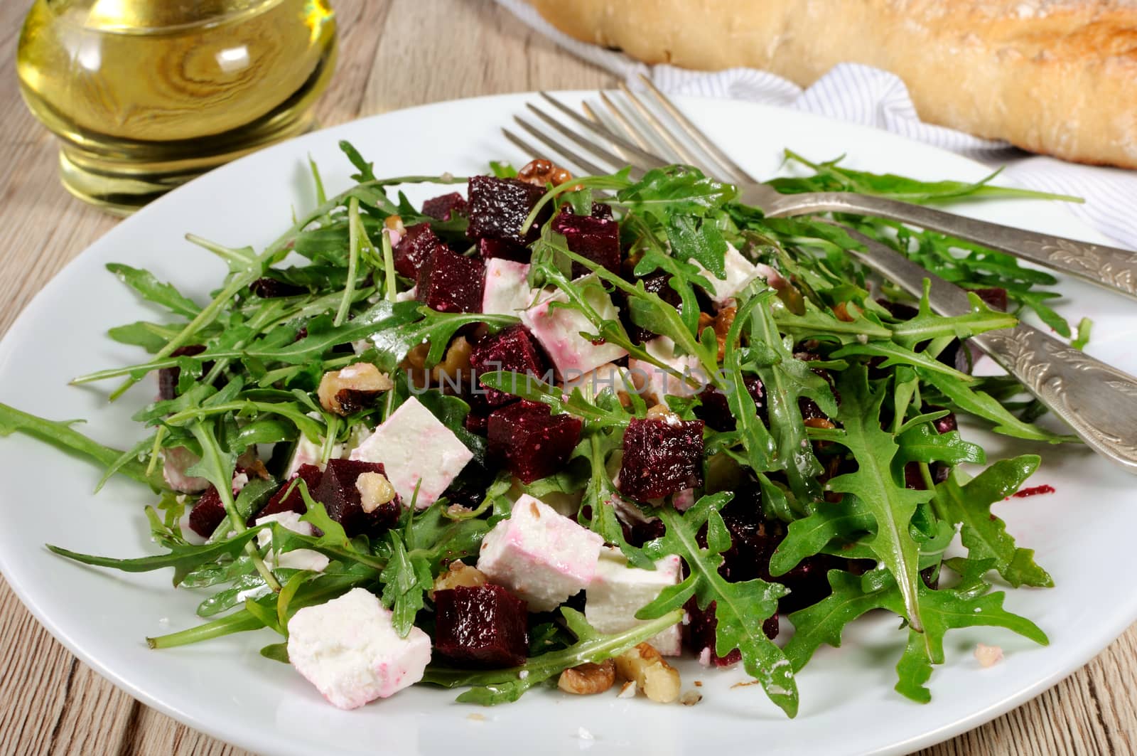 Salad from roasted beets, arugula, cheese feta, and walnuts. Horizontal shot. Foreground close-up.