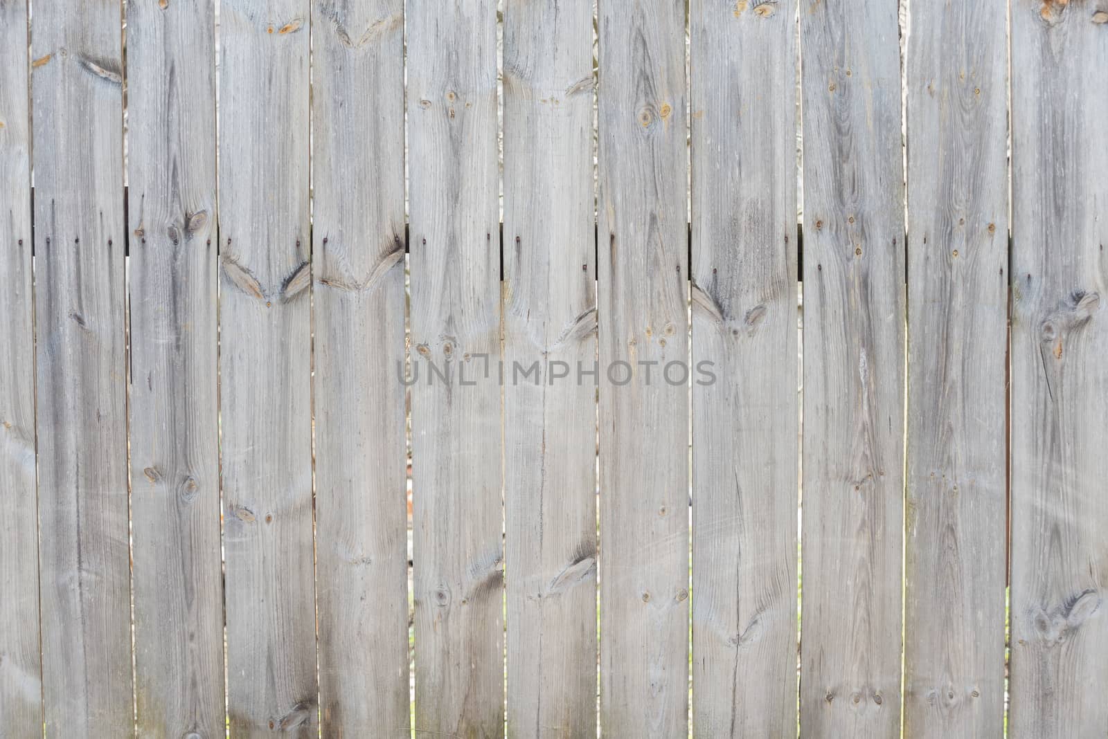 Unpainted gray wooden door consisting of old weathered unpainted boards