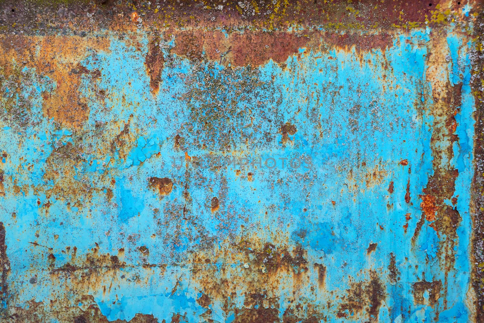 Multicolored background: rusty metal surface with blue paint flaking and cracking texture