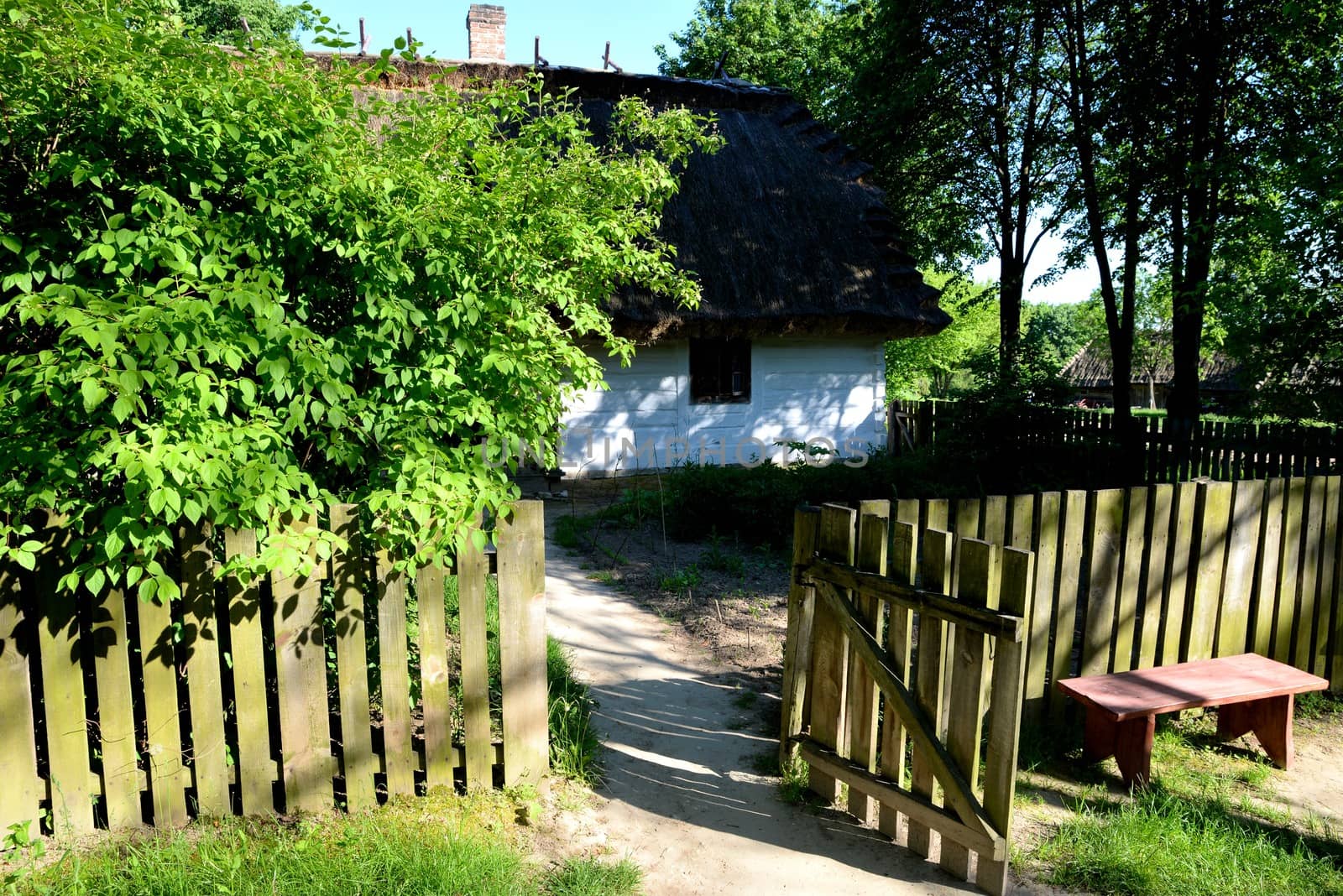 Wide open wooden gate overlooking the garden and country house