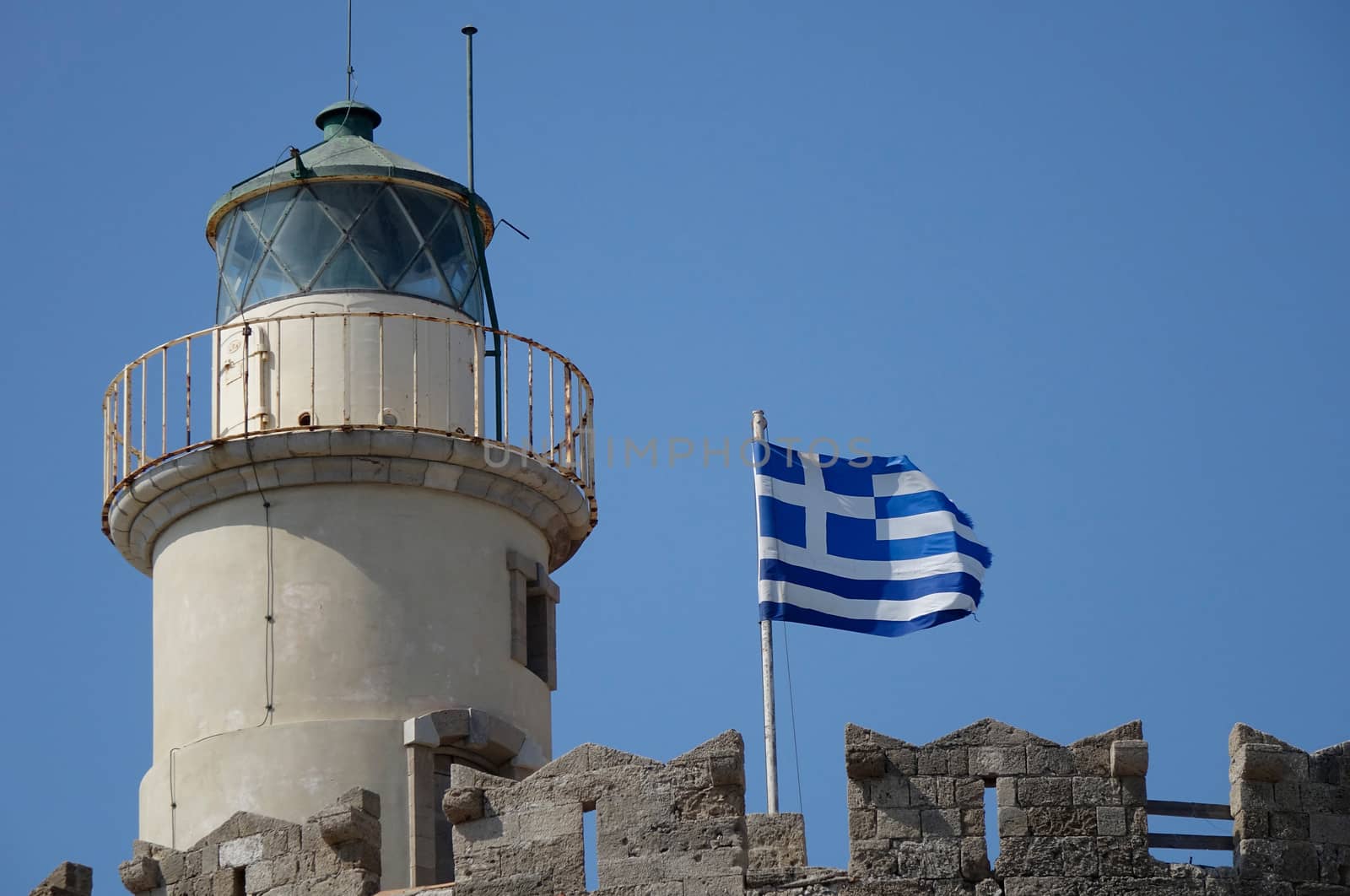Low angle view of a lighthouse with a Greek flag