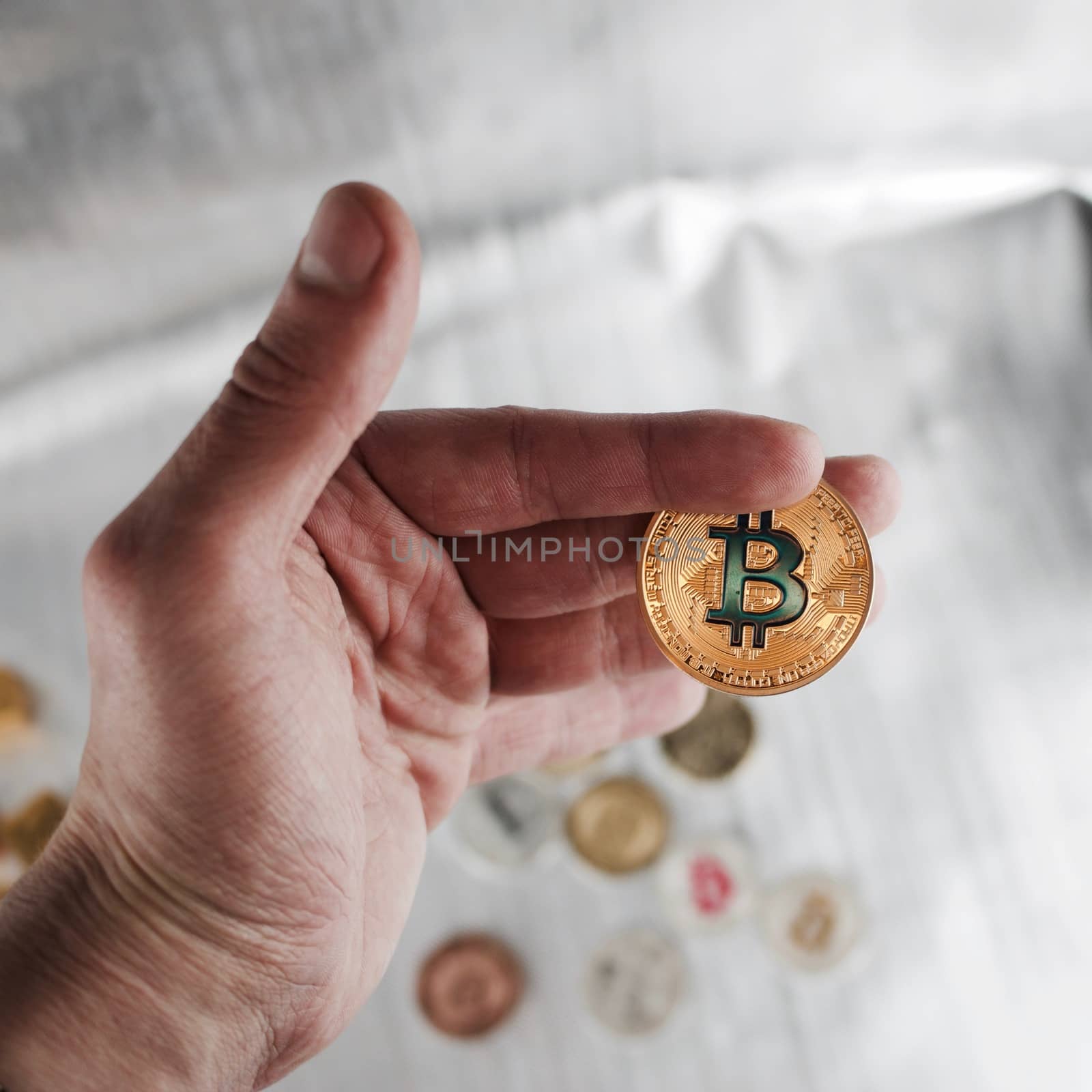 Digital currency physical gold bitcoin coin in man hand.