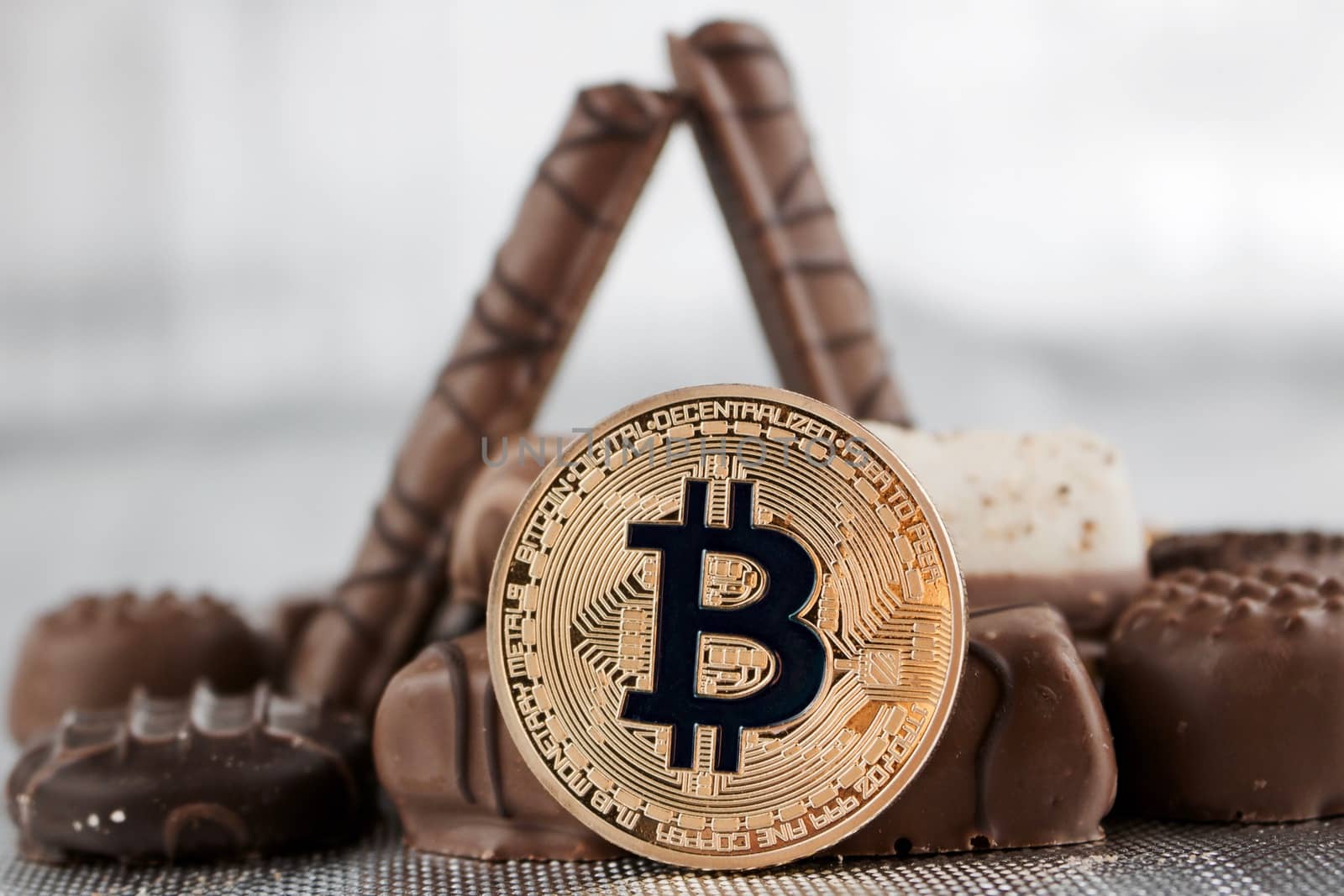 Digital currency physical gold bitcoin coin and sweet chocolates.