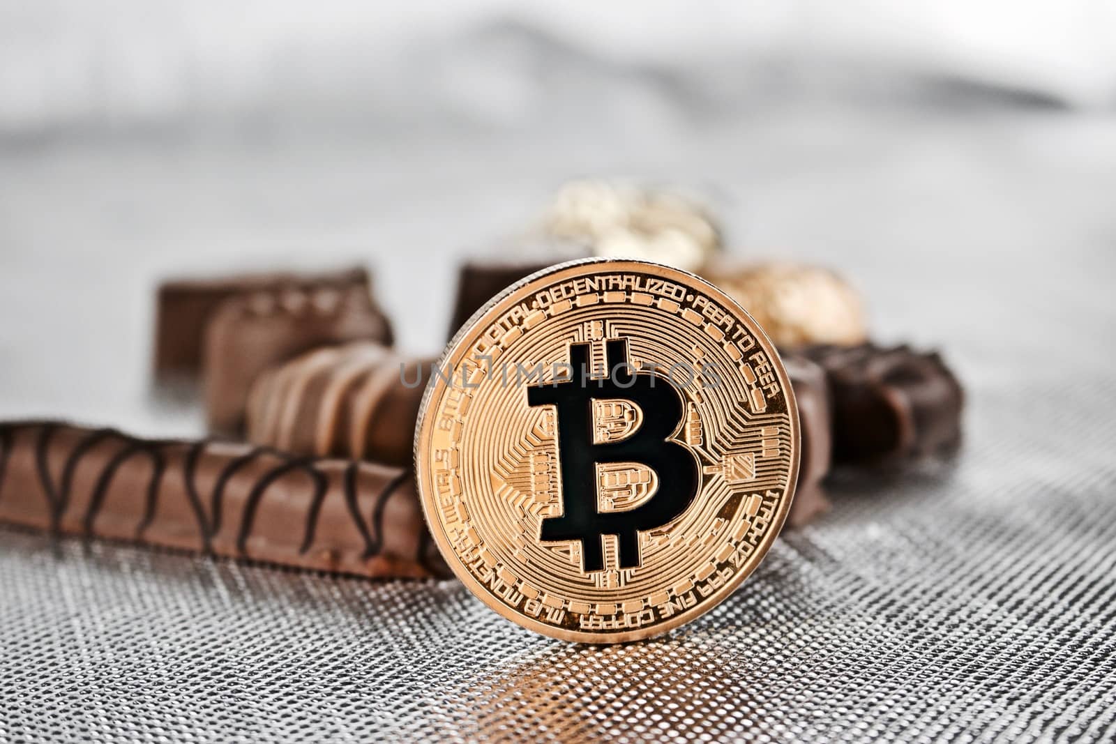 Cryptocurrency physical gold bitcoin coin and sweet chocolates.