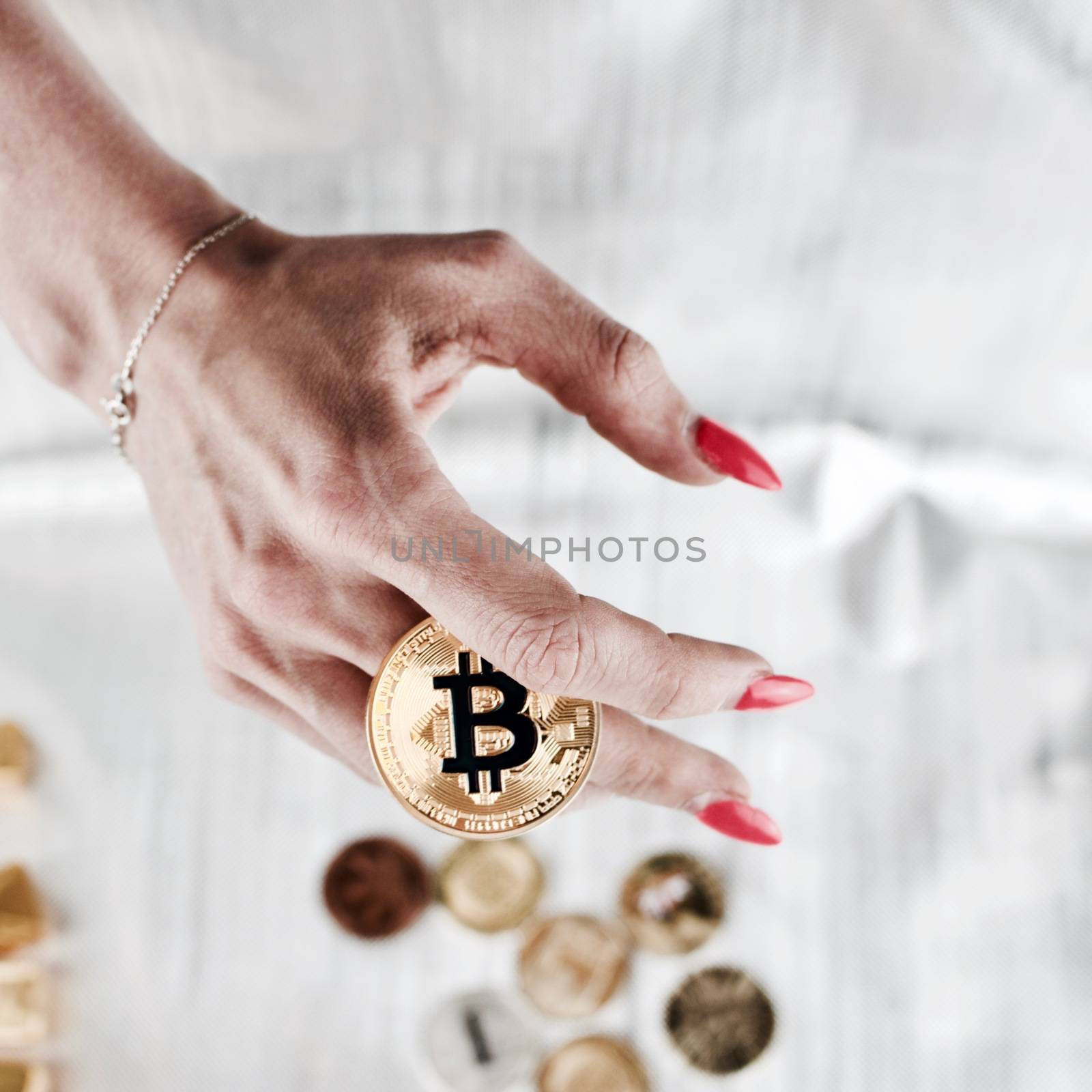 Cryptocurrency physical gold bitcoin coin in woman hand.