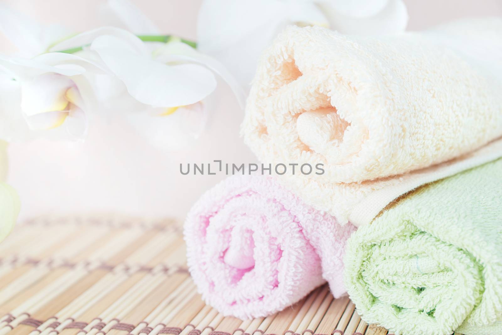 Spa concept: bath towels and a branch of white orchid, with space for text
