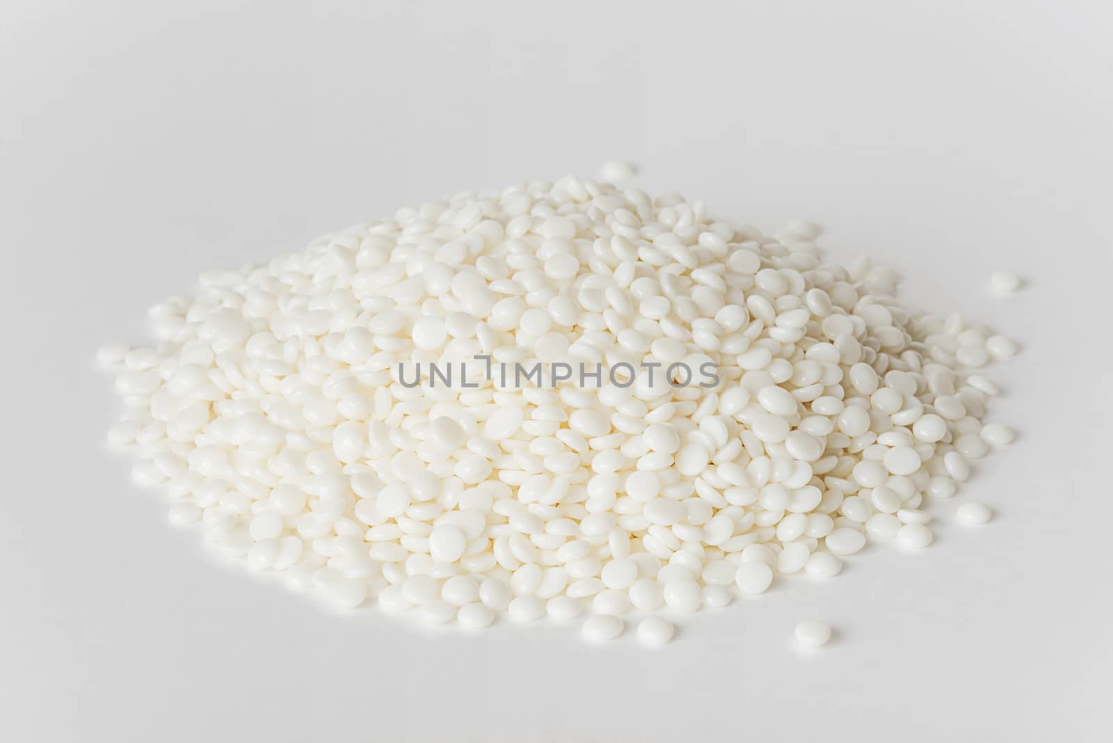 Heap of fine white thermoplastic granules on the white background