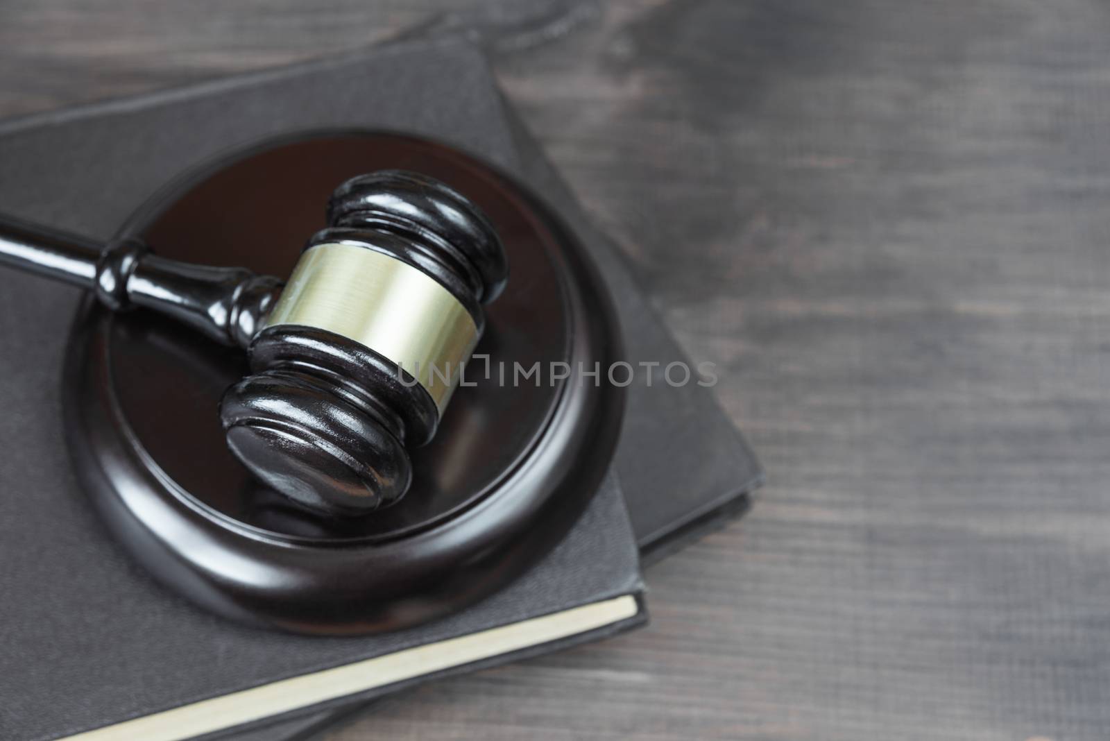 Wood gavel and on the old book on a dark wooden background, top view