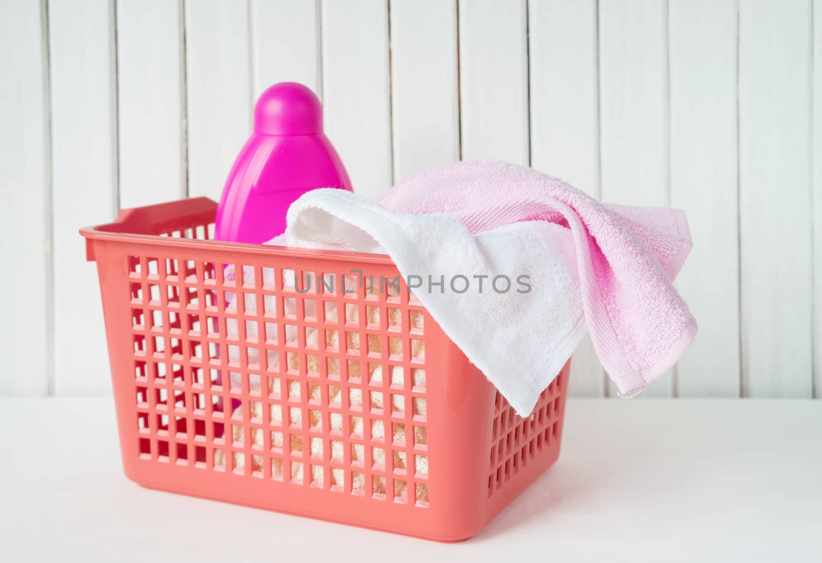 Terry towels and detergent in the laundry basket by Epitavi