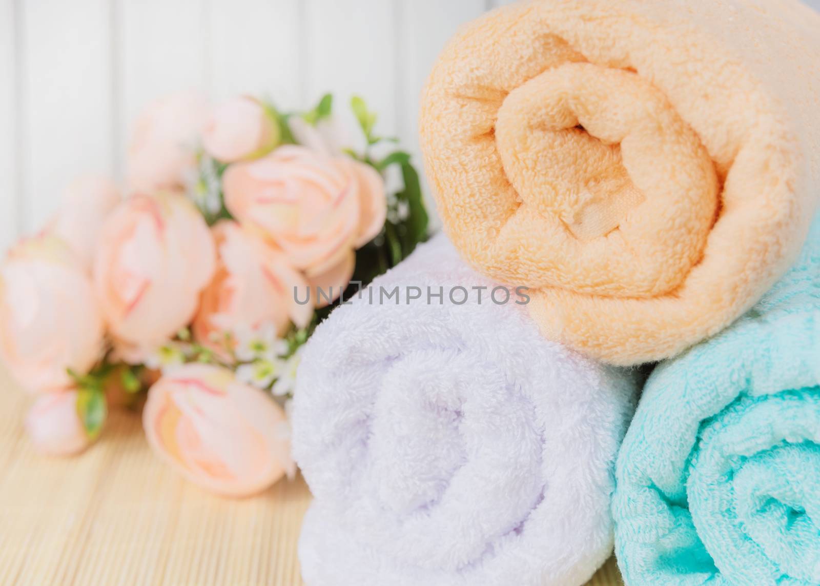 Spa concept: bath towels and bouquet of pink flowers