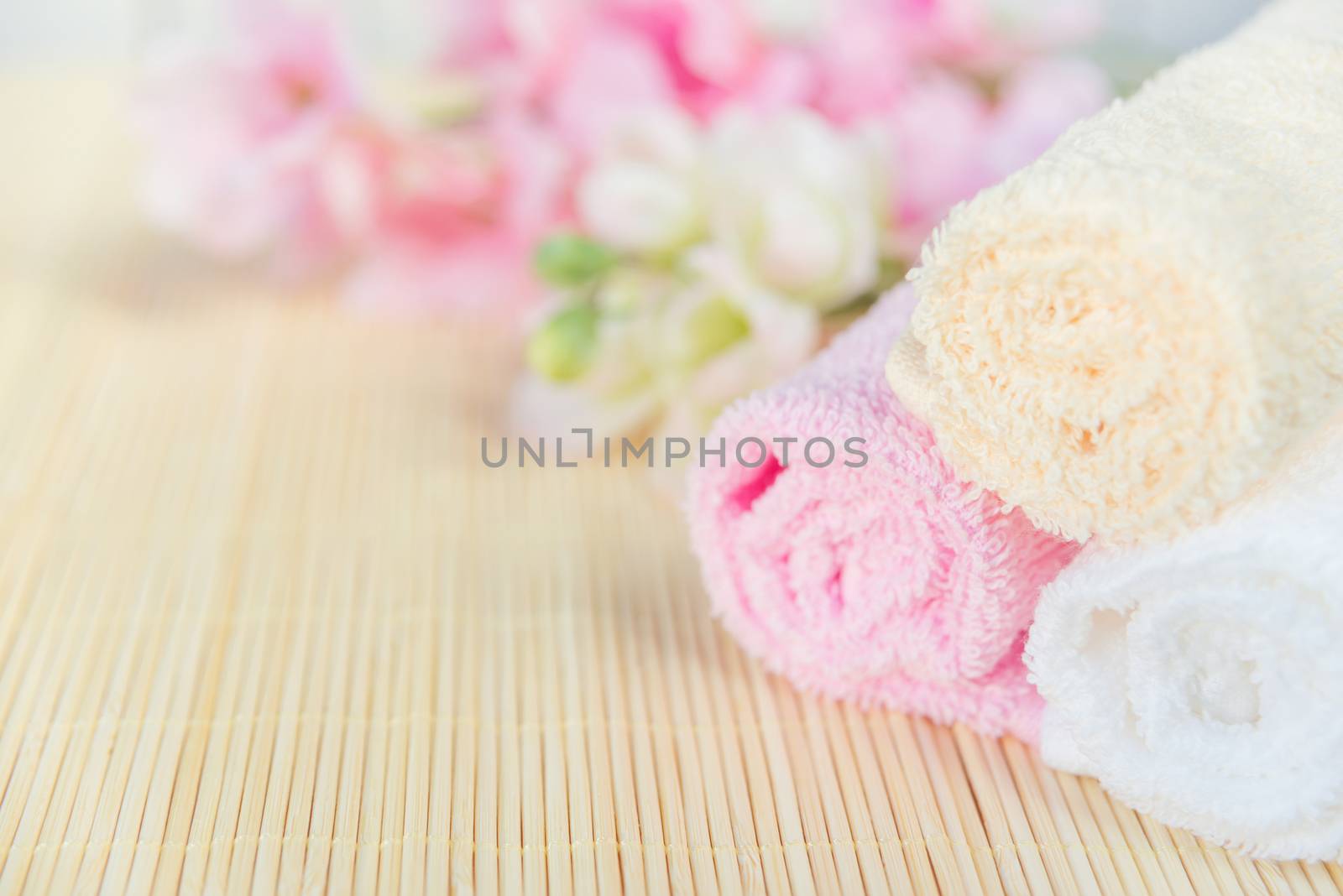 Spa concept: bath towels and bouquet of pink flowers