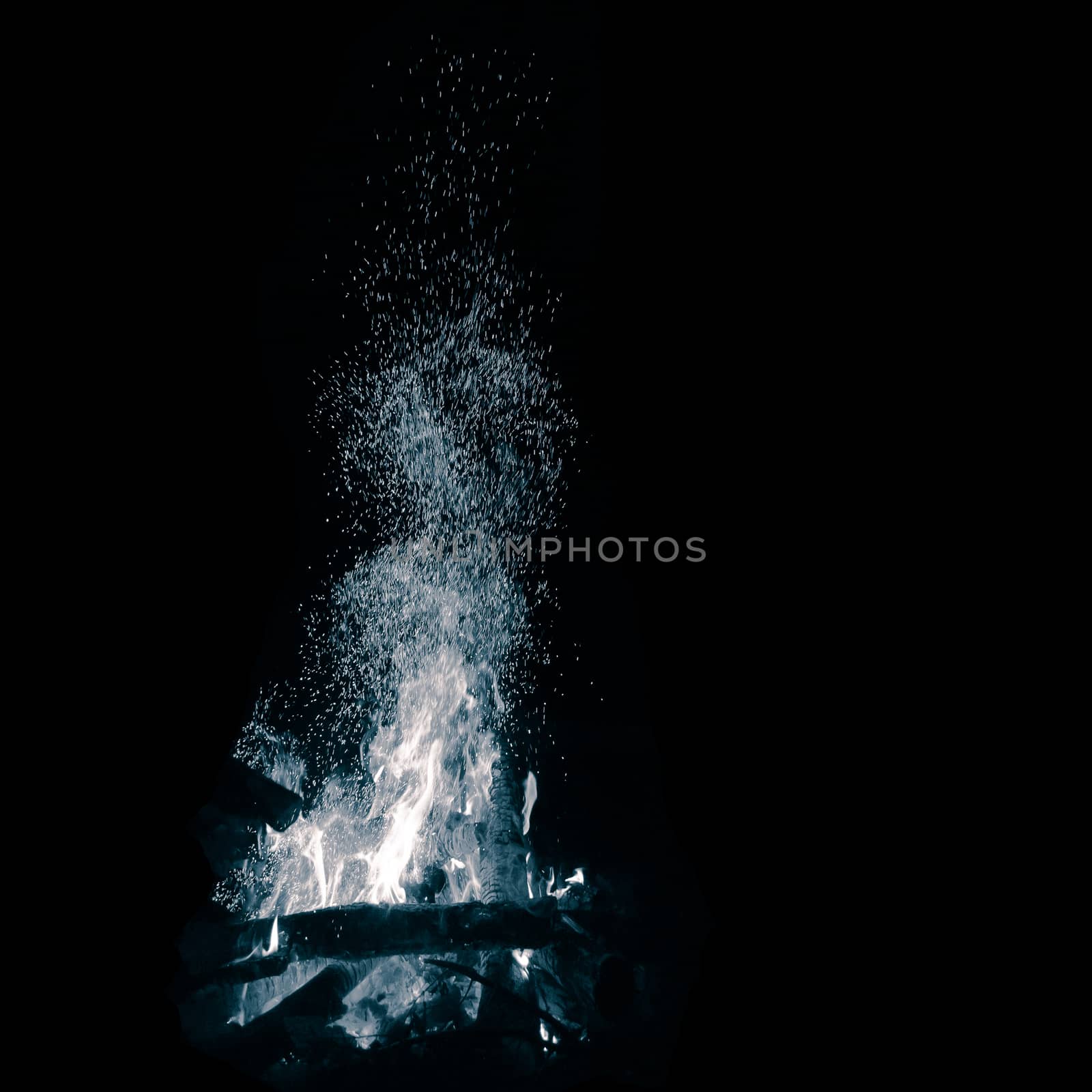 Blue bonfire with flying sparks isolated on black