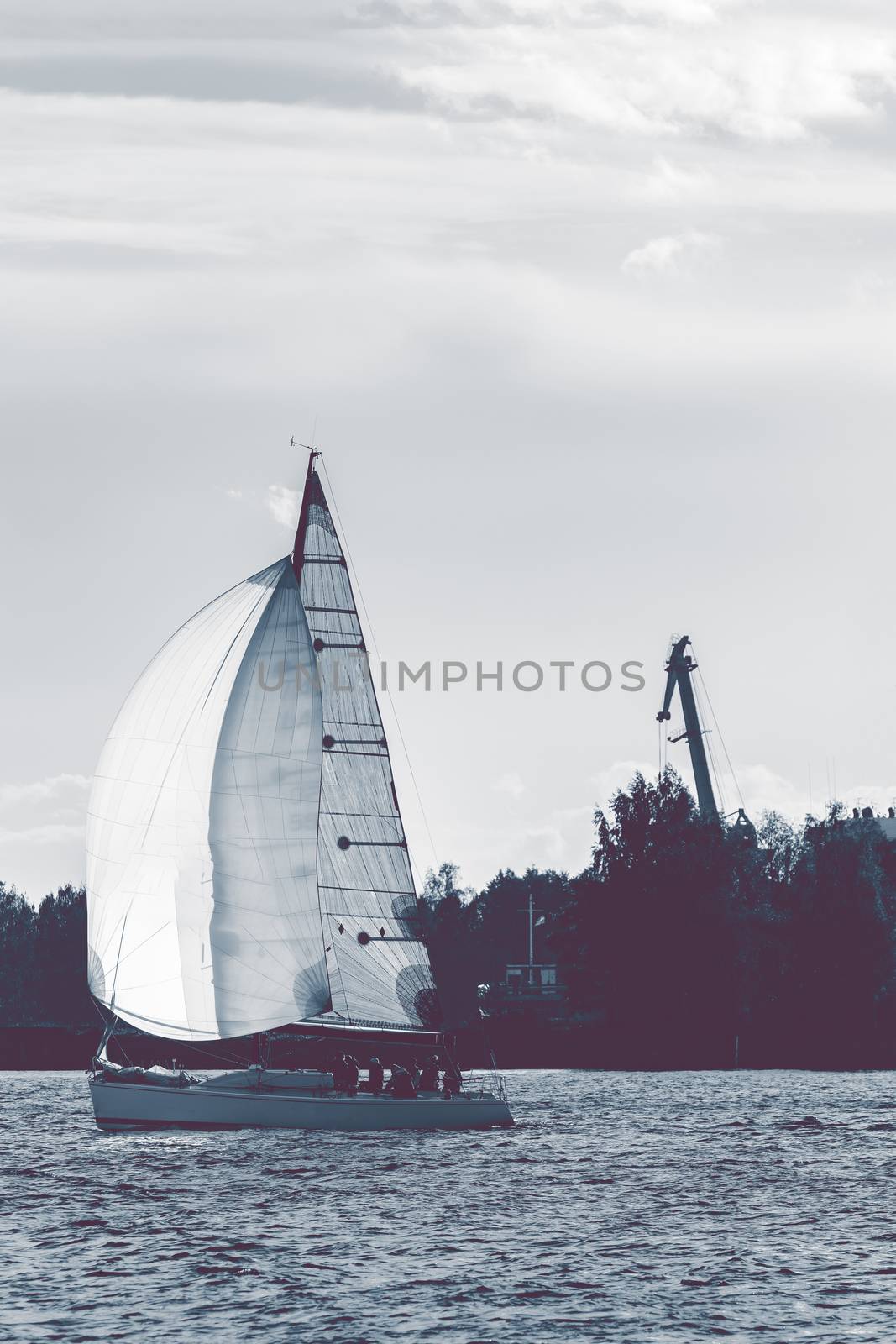 Sailboat moving on Daugava river in evening, Latvia