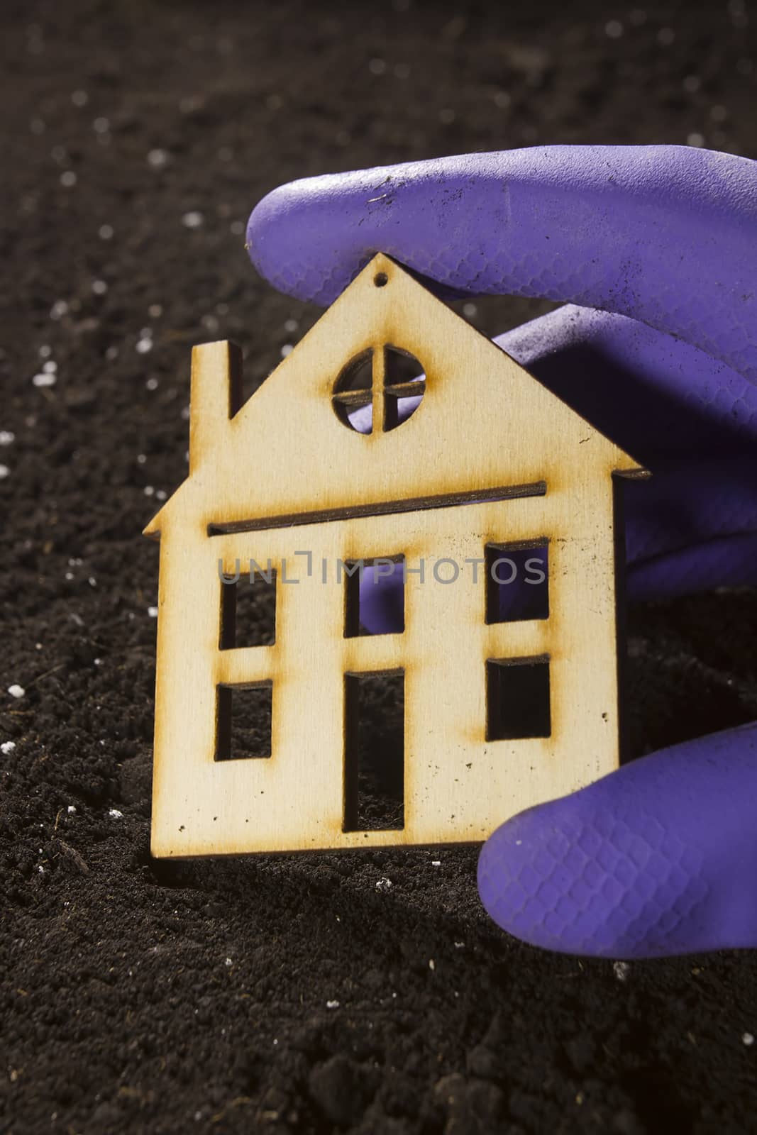 Model of a house in hand on a background of a ground