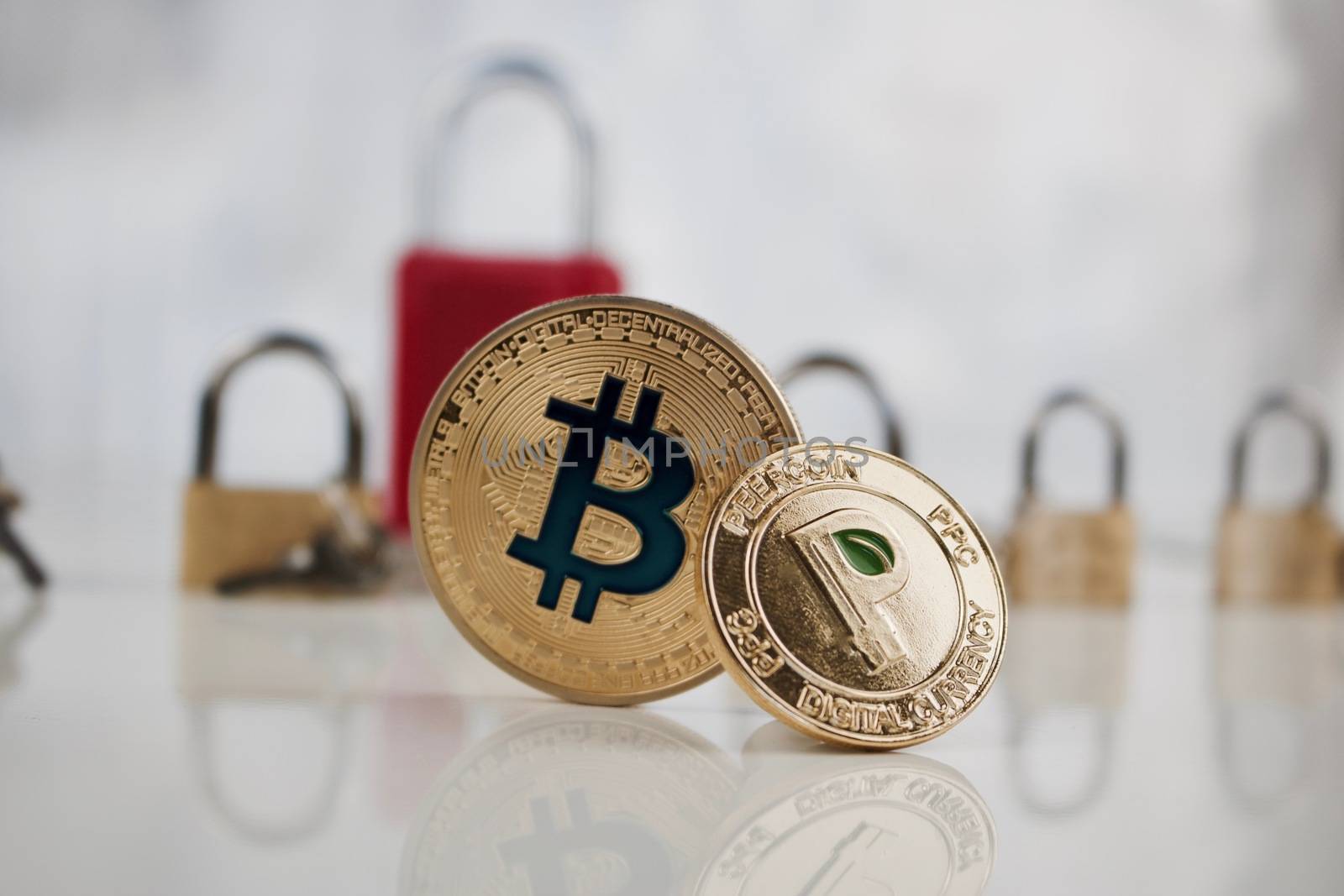 Digital currency physical gold bitcoin coin and gold peercoin coin.