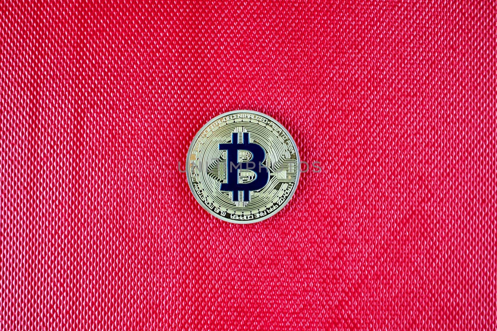 Cryptocurrency physical gold bitcoin coin on red scene. Blue bitcoin.